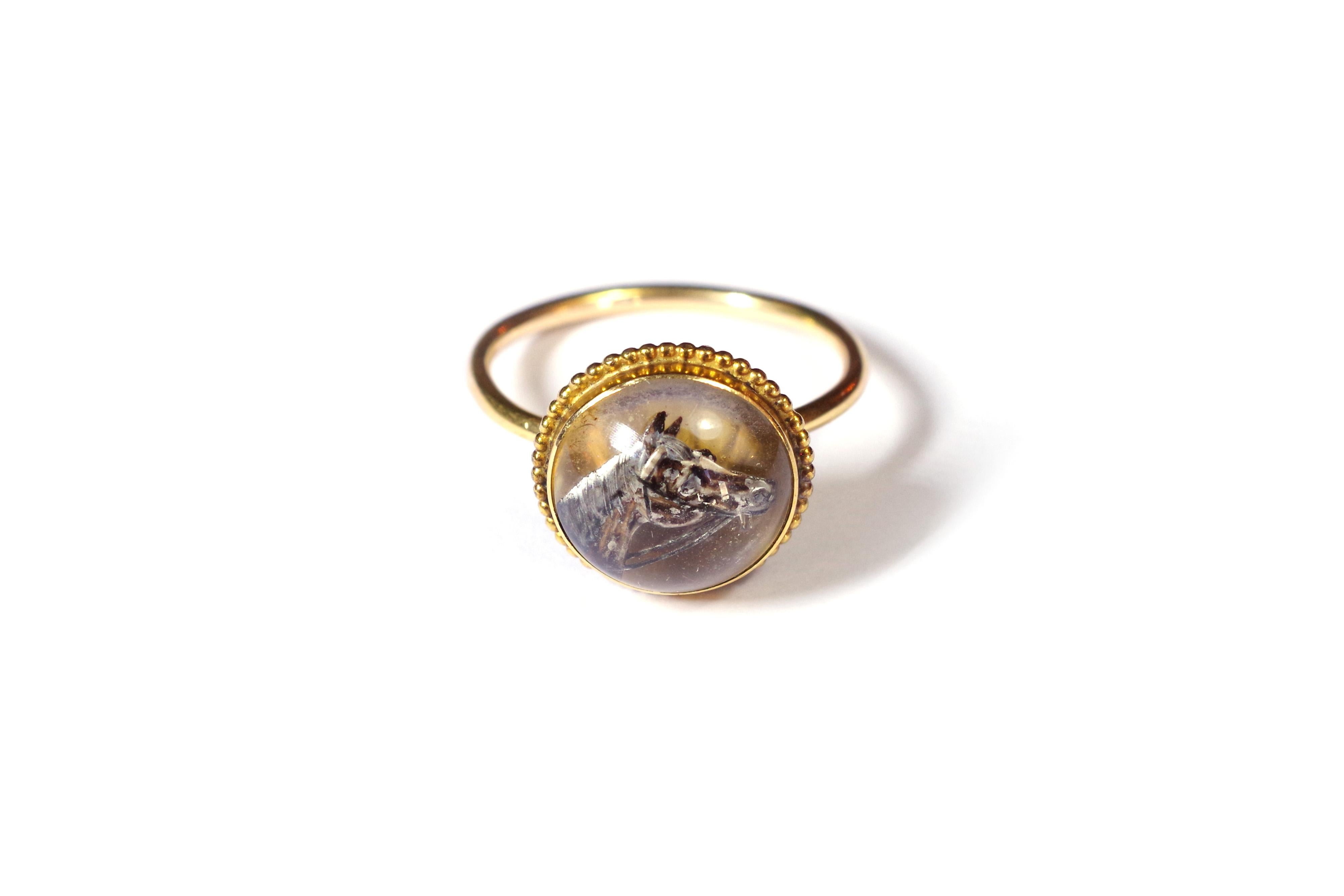 Essex crystal horse ring in rose gold 18 karats. Antique Edwardian ring decorated with a crystal of Essex of round form, carved inside of a head of horse on a gold bottom. The rock crystal is polished and set in closed, the contour of the setting is