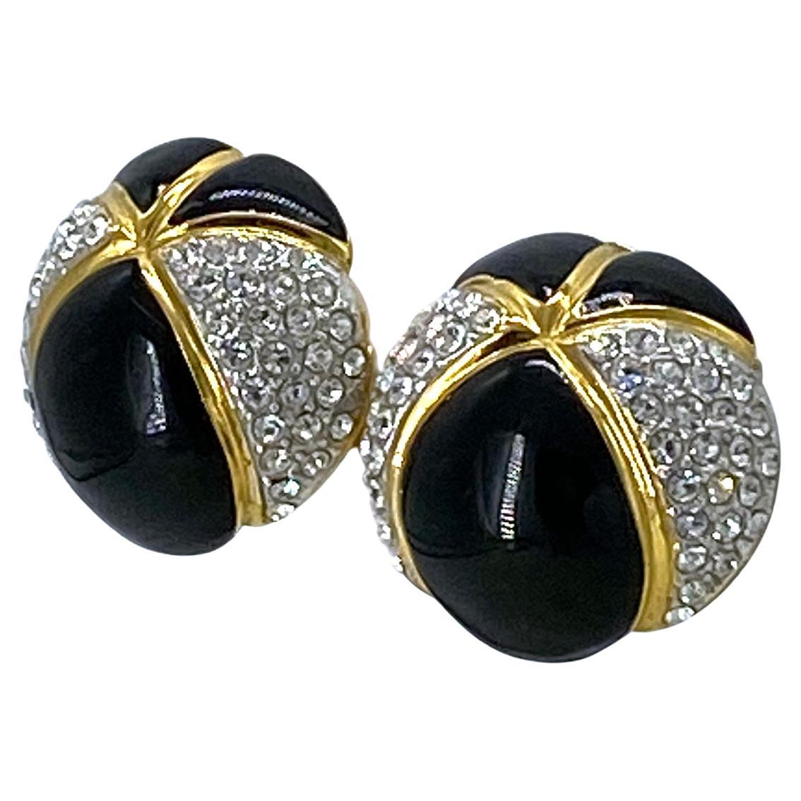 Si tratta di un paio di orecchini a clip da passerella firmati Essex couture. Gli orecchini a forma di cupola in smalto nero hanno cristalli trasparenti incastonati su metallo placcato oro. ESSEX firmato con una texture martellata all'interno delle