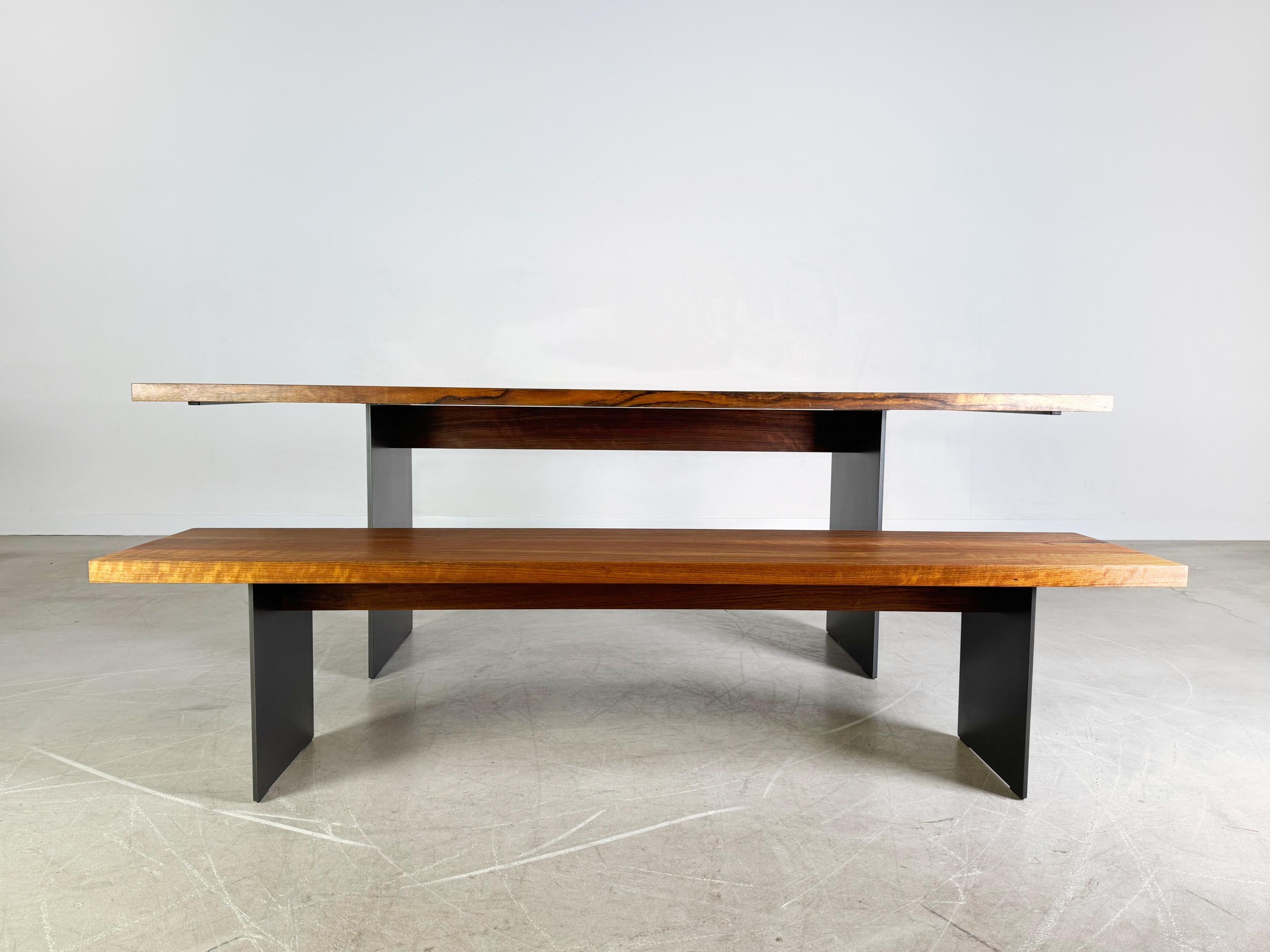 Wir bieten einen wunderschönen Esstisch von Janua (Modell SC 41) mit passender Sitzbank zum Verkauf an. Die in der Länge durchgängig massive Nussbaumplatte wird von zwei eleganten Wangenfüßen aus reinem Stahl getragen. Die Maße der Sitzbank lauten