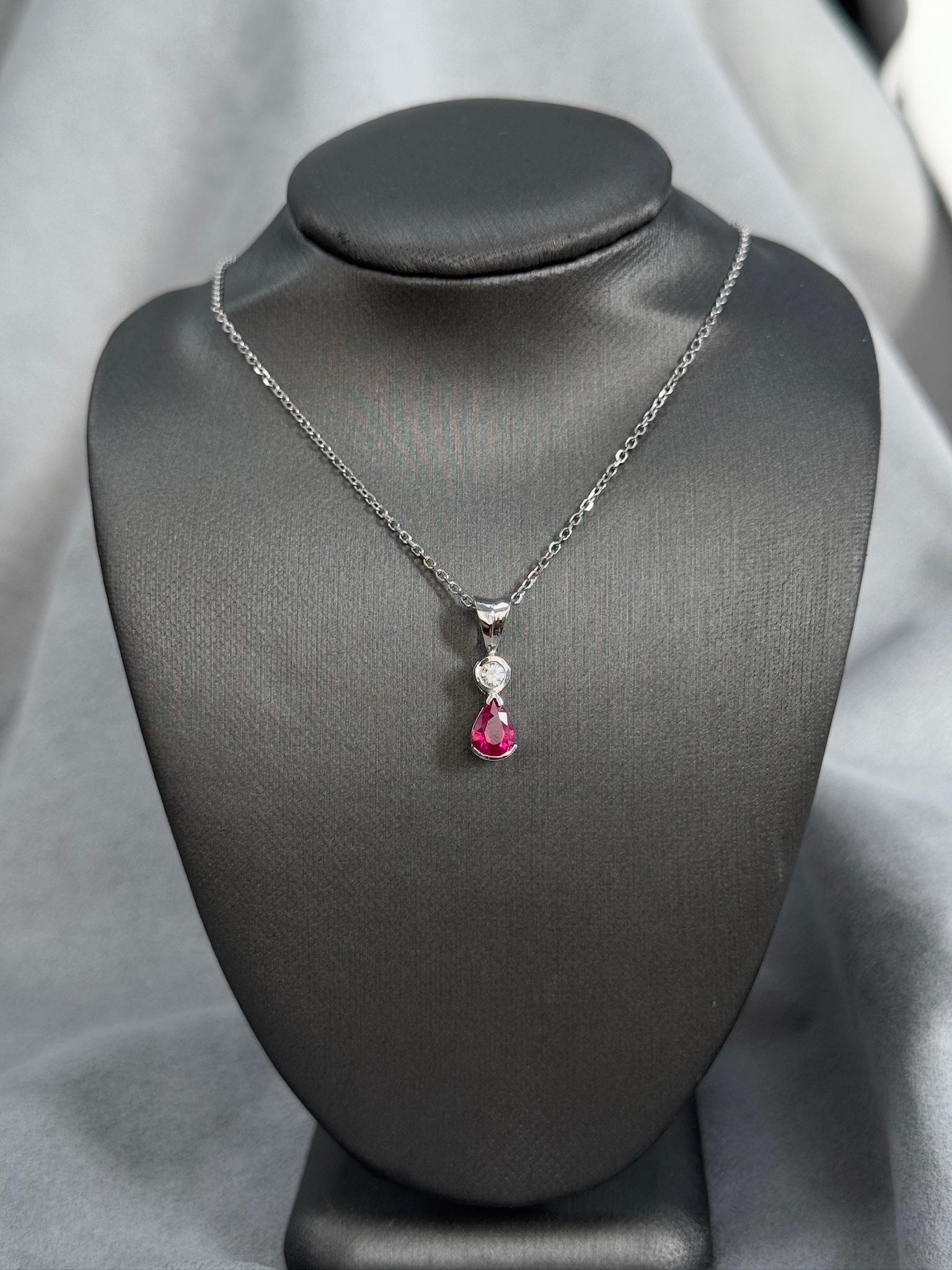 Délicat et élégant, ce pendentif est orné d'un rubis naturel en forme de poire de 0,74ct, rehaussé d'un diamant étincelant de 0,07ct. Fabriqué en or blanc 14k, ce pendentif de 1,4 g est léger tout en attirant l'attention, ce qui le rend parfait pour