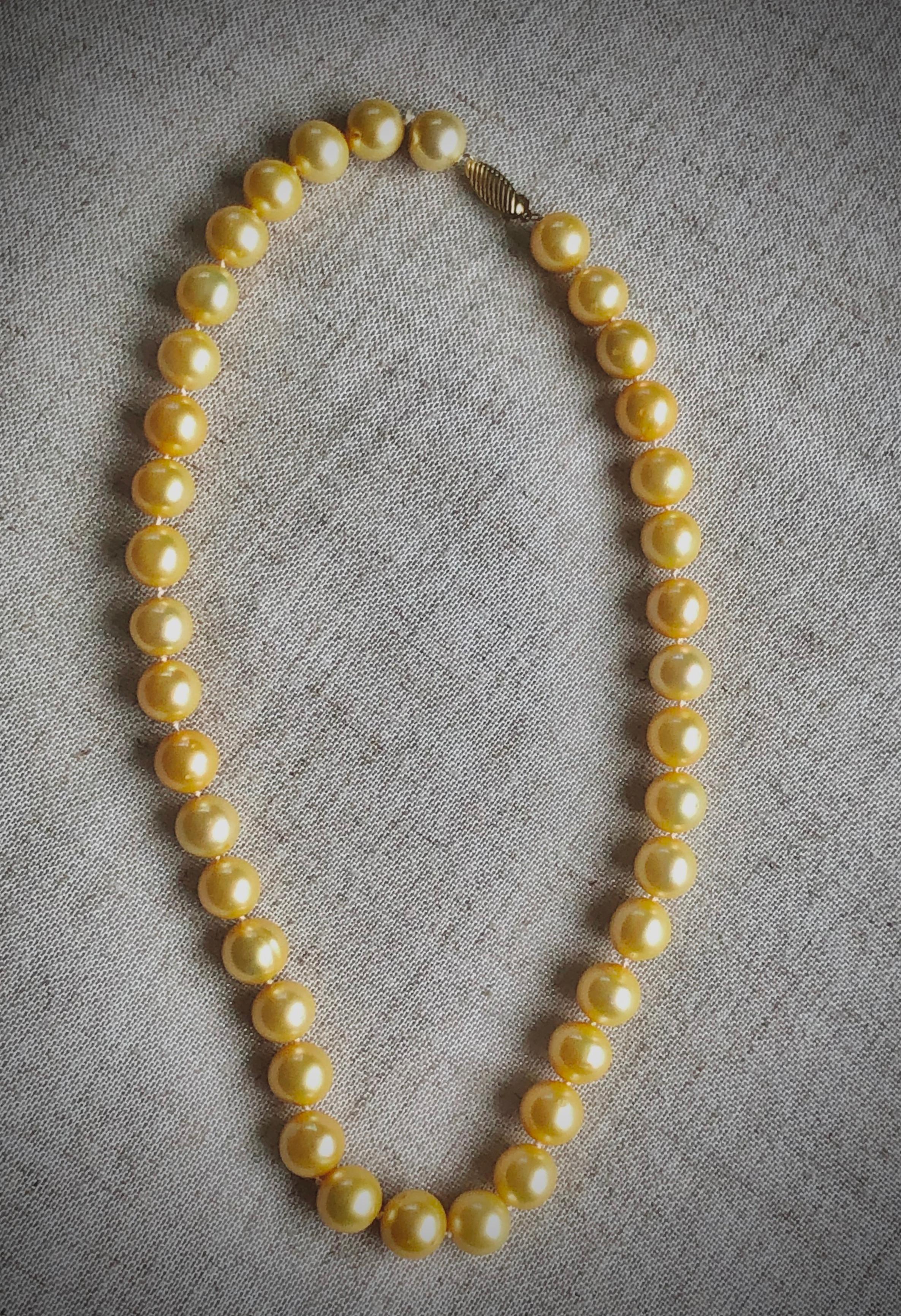 Golden South sea cultured pearl necklace. Good luster, quality, color and cleanliness. Individually knotted, this beautiful strand make 17.5 inches long necklace (including clasp). The necklace is affixed with 14k gold clasp. 
Length: 17.5