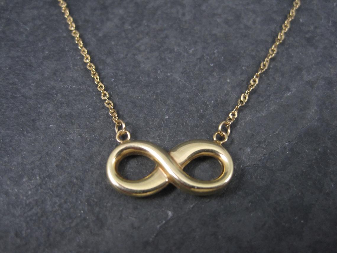 This gorgeous necklace is 10k yellow gold.
It features an infinity sign pendant.

The pendant measures 3/4 of an inch.
The necklace is 16 inches.

Marks: Turkey, MA, 10K

Condition: Excellent