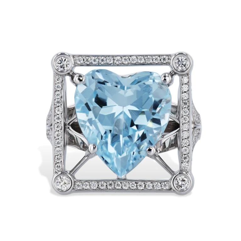 This stunning estate ring features a huge 13.18 carat heart shaped blue topaz. It is set in 18 karat white gold. 

There are an additional 85 diamonds surrounding the blue topaz. The total carat weight of diamonds are 0.62CT.
Their color is H, and