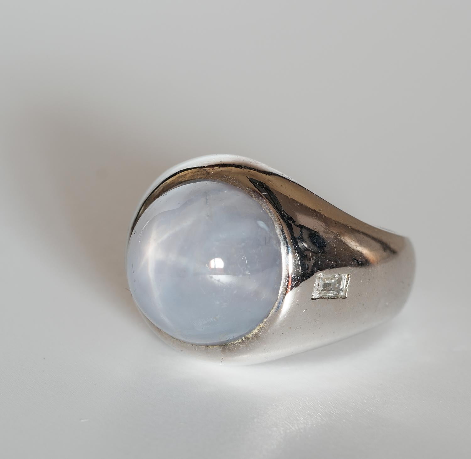This beautiful estate Gent ring is 1945/50 ca.
Individually hand crafted of solid 18 KT white gold, marked
Traditional design suitable for either sex, displaying a beautiful polished plain mount with two sides square Diamonds flanking the large