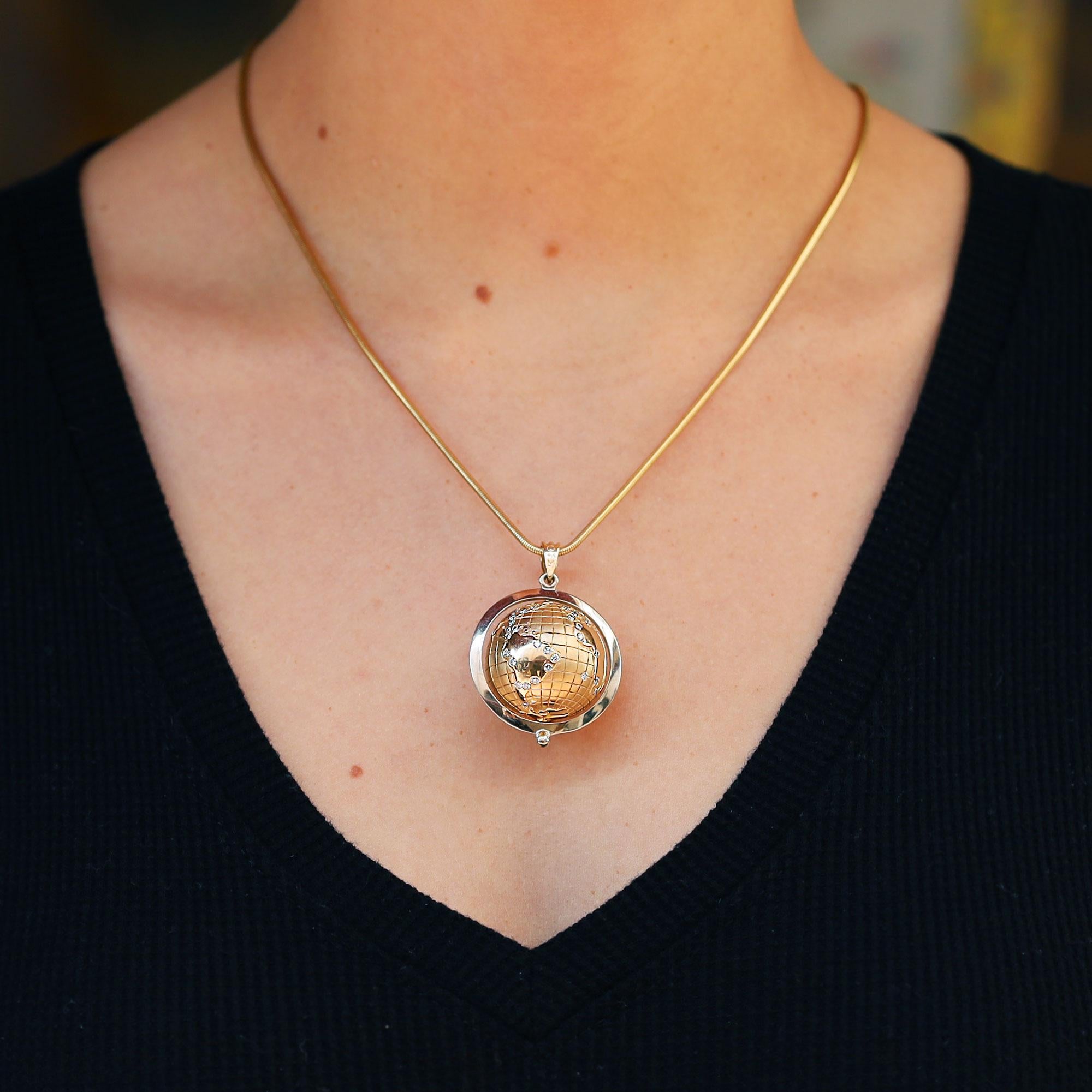 Il mondo è tuo. Ecco la tua occasione per festeggiare come se avessi vinto i Golden Globe, con questo ciondolo in terra vintage unico e di alta qualità. Sapientemente realizzata in oro giallo e bianco da 14 carati, la terra ruota rivelando tutti i