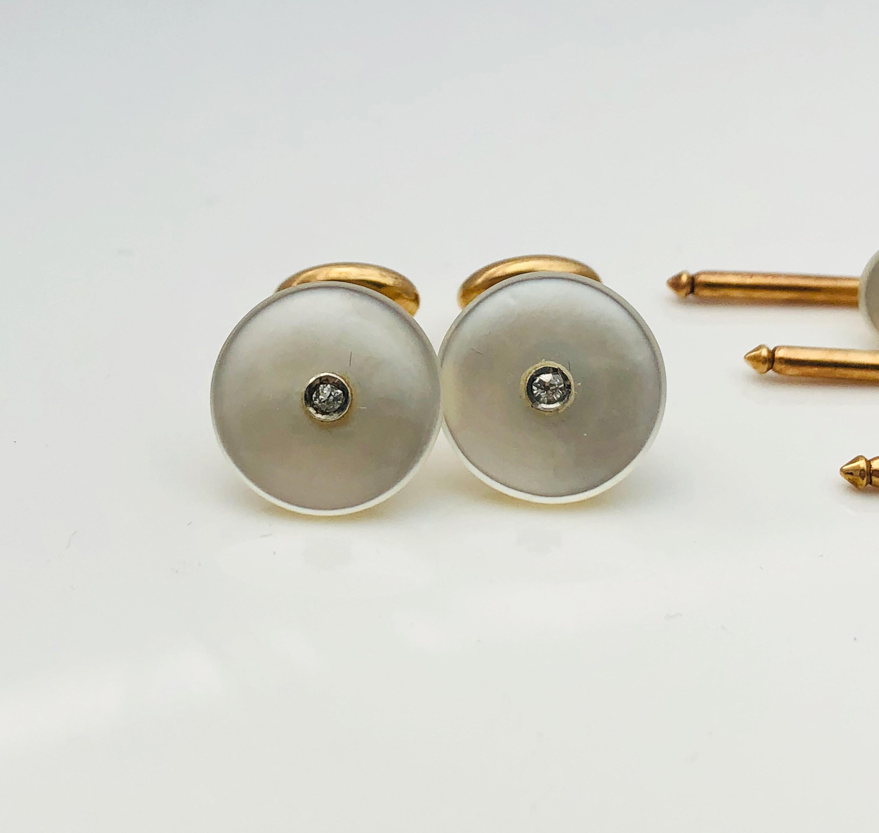 This is a lovely Art Deco Tuxedo Set! This estate set is made in 14K Yellow Gold and features cufflinks and studs that have a round mother of pearl base that is set with sparkling round diamond accent at the center. The cufflinks measure 1/2 inch in