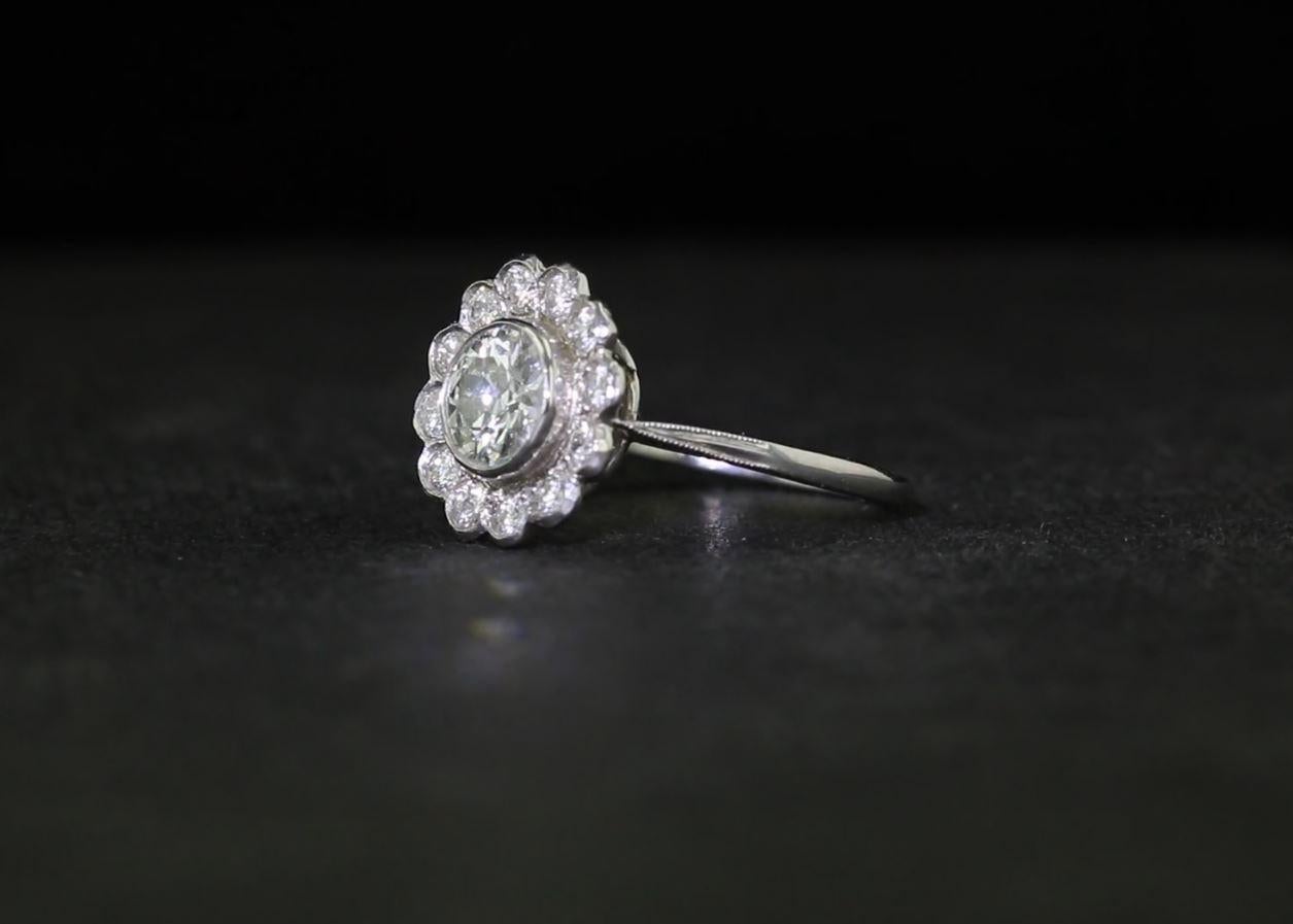 In the center of this platinum and diamond engagement ring is an Old European cut diamond with an approximate weight of 0.85 carat.  Surrounding the center diamond are a dozen additional Old European cut diamonds with an approximate total weight of