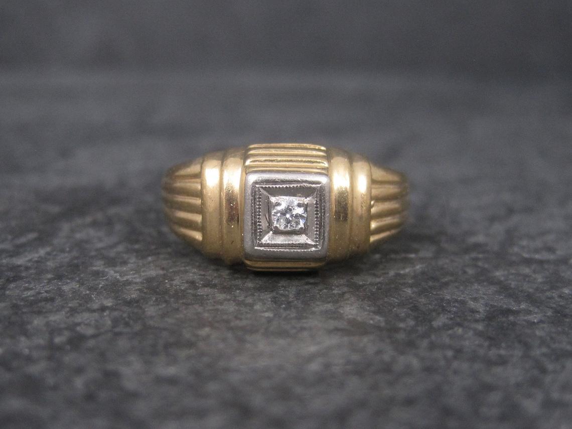 This beautiful vintage ring is a combination of 14K yellow gold and white palladium.

It features a small, natural 2mm round cut diamond.

The face of this ring measures 3/8 of an inch north to south with a rise of 4mm off the finger.
Size: