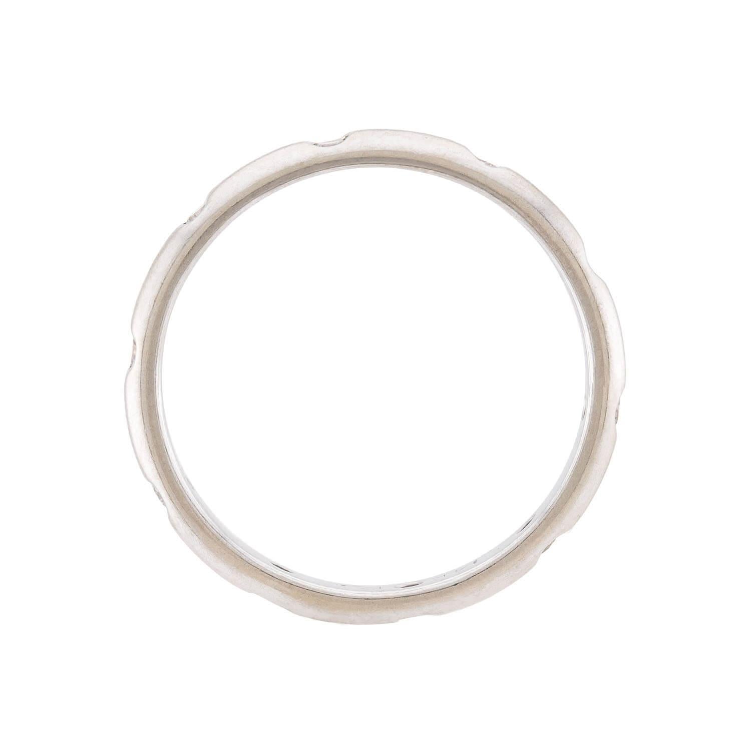 A stunning diamond band! Crafted in elegant 14k white gold, this band features 9 small, sparkling diamonds. All of the stones are held within bezel settings, which allows the diamonds to blend seamlessly into the smooth and simple band. The inside