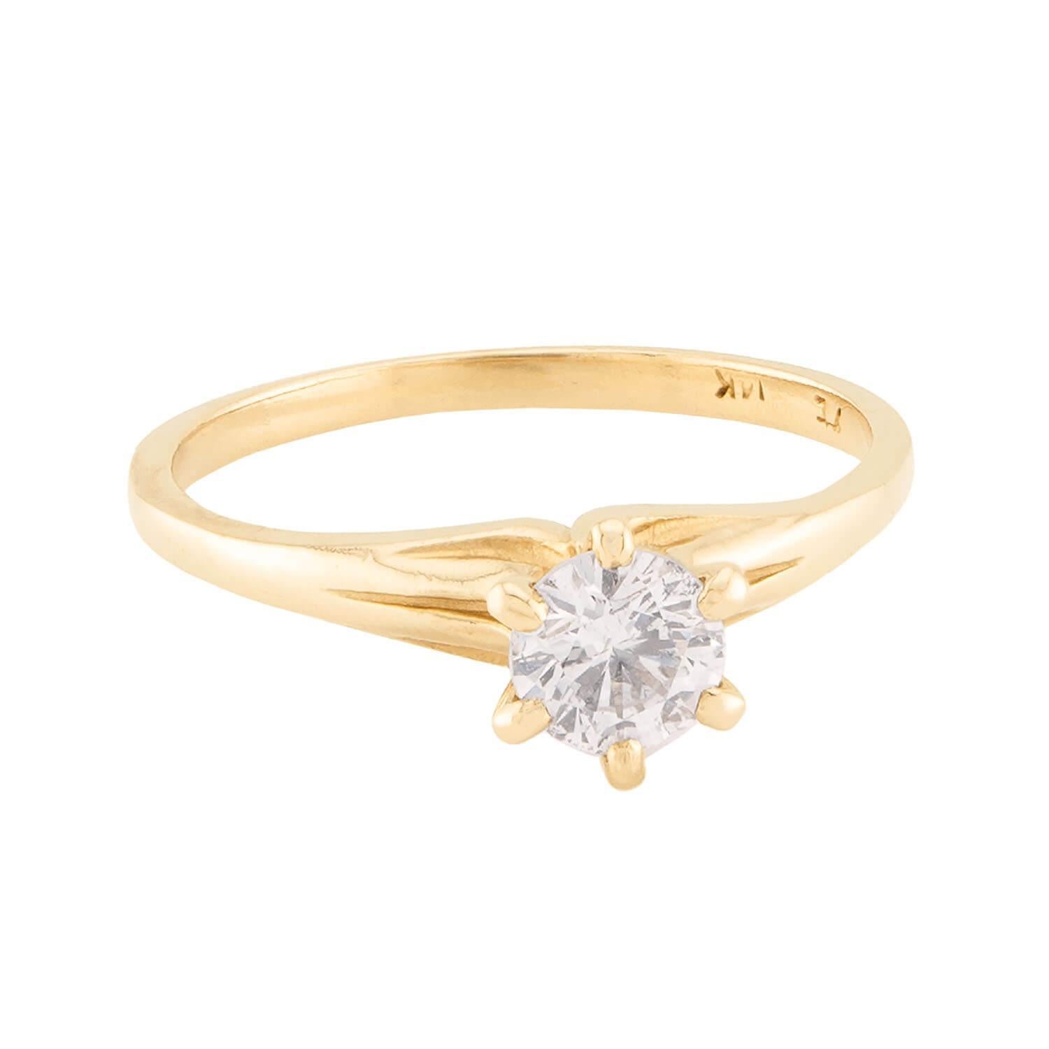 Uno splendido anello di fidanzamento con diamante! Realizzato in oro giallo 14 carati, questo anello presenta un moderno diamante rotondo taglio brillante da 0,54 carati, incastonato in una montatura a sei punte. La pietra ha un colore I e una