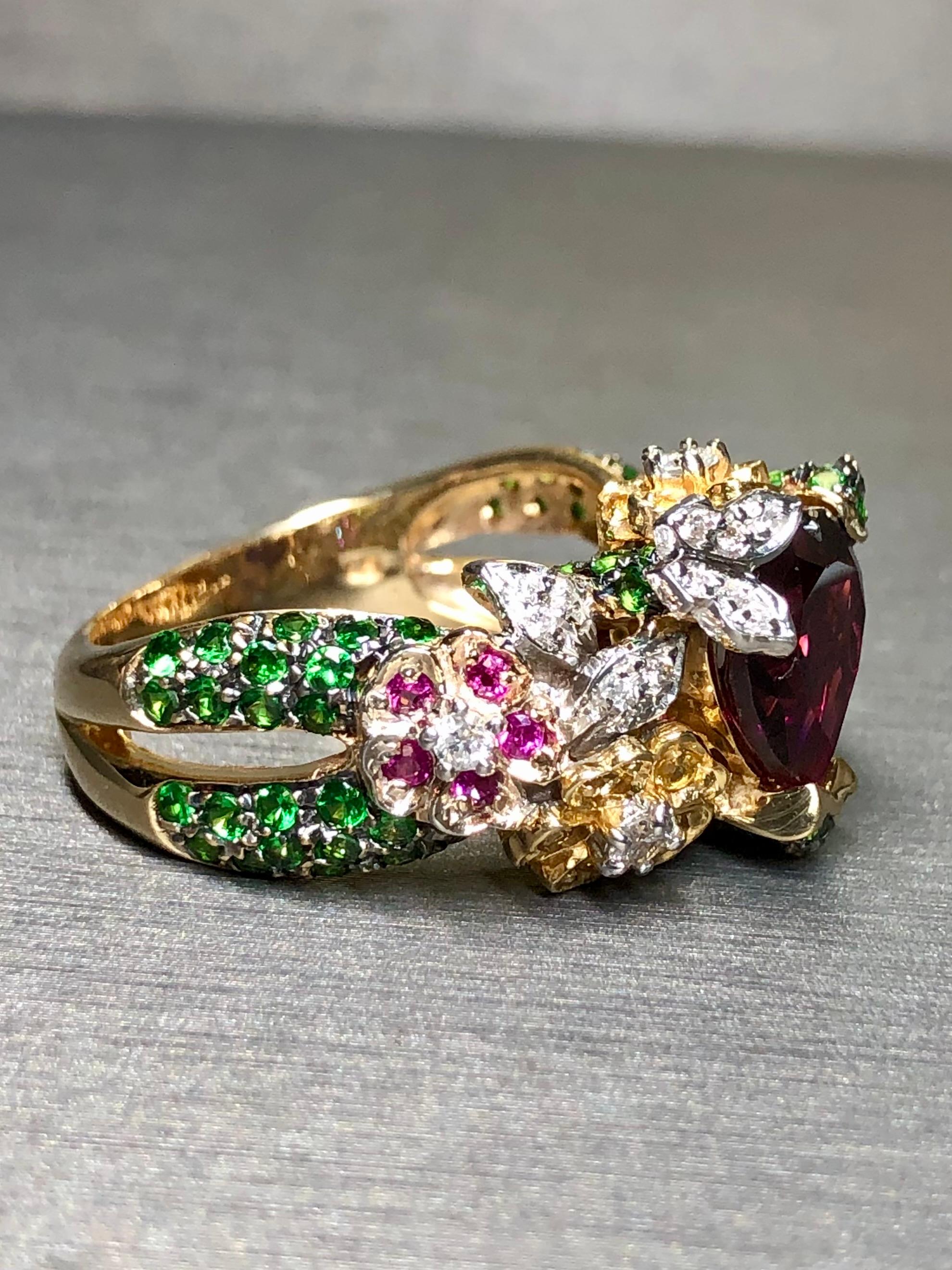 
A bright and fun statement ring crafted in 14K yellow gold and centered by an approximately 4.70ct heart shaped tourmaline flanked by 2cttw in tsavorite garnets, .30cttw in natural rubies and .40cttw in H-I color Si1-2 clarity round diamonds. All