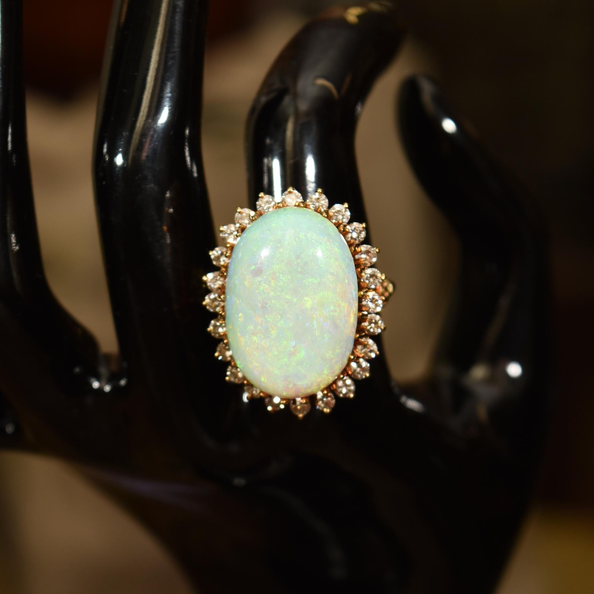 An astounding estate 14K opal diamond halo cocktail ring. Features a huge oval white opal cabochon, 18kt two-tone gold opal and diamond halo ring. Featuring an oval shape cabochon opal center stone, estimated at 14 carat, measuring approximately