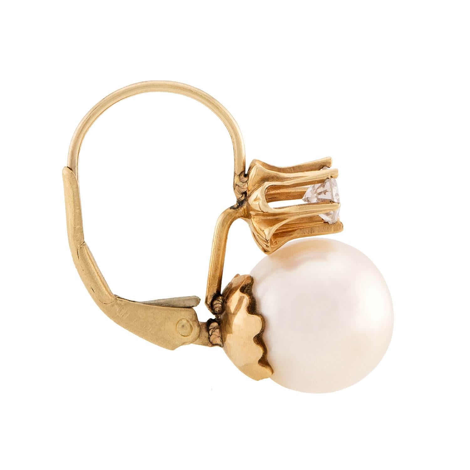 A beautiful pair of pearl and diamond earrings! Crafted in 14k yellow gold, each earring begins with a small six-prong set modern round brilliant cut diamond. The diamonds are followed by a wonderful pearl, which each display a lovely milky white