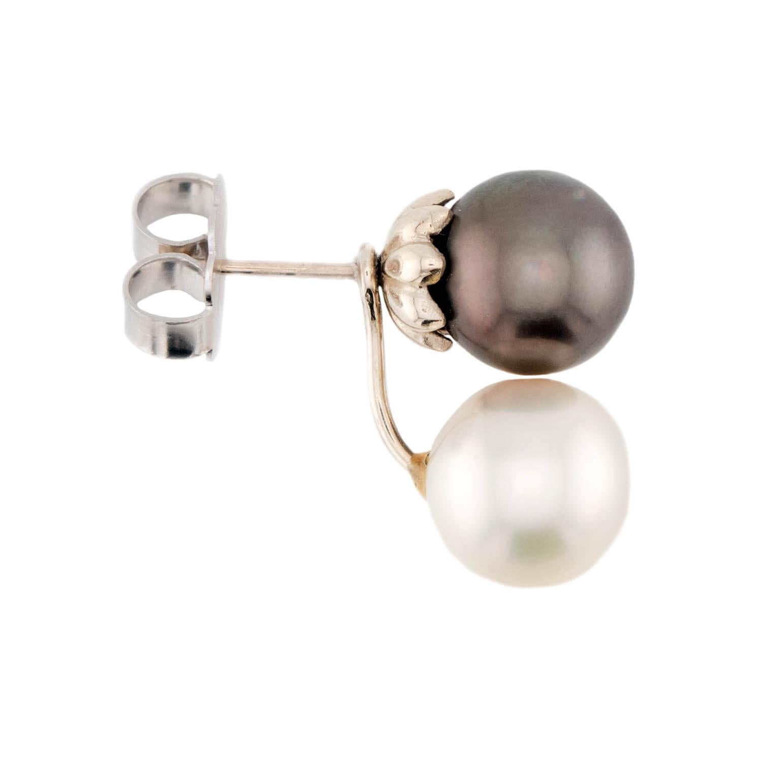 Un bel paio di orecchini con perle! Realizzato in oro bianco 14 carati, ogni orecchino inizia con una perla di Tahiti scura. Le perle tahitiane mostrano un'incredibile lucentezza nero-violacea e sono sostenute da dorsi smerlati a 14k. Sotto ogni