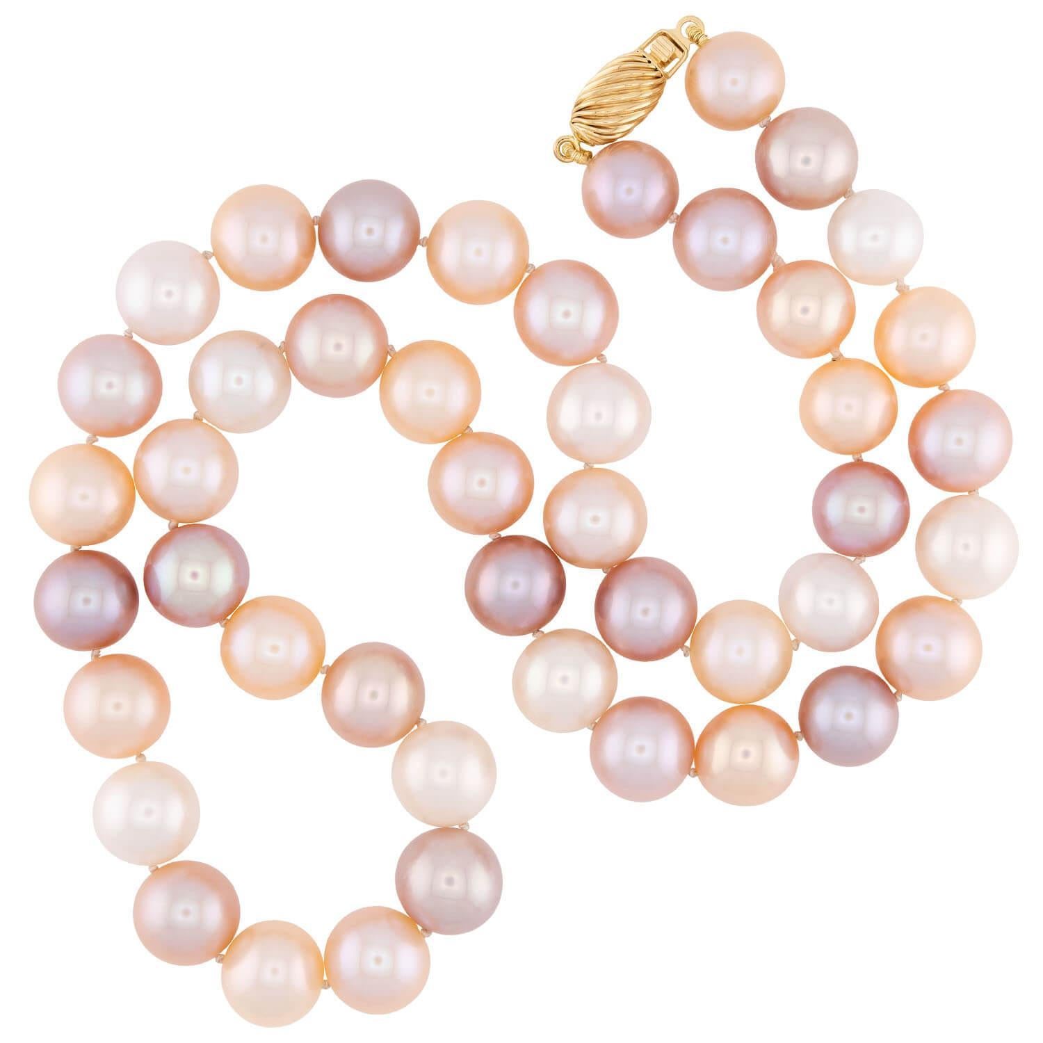 A classically beautiful Estate pearl necklace! This colorful piece is comprised of 9mm South Sea pearls, which are individually knotted on white cord. he pearls vary in color, and capture champagne, milky white, and rosy pink hues. The piece secures