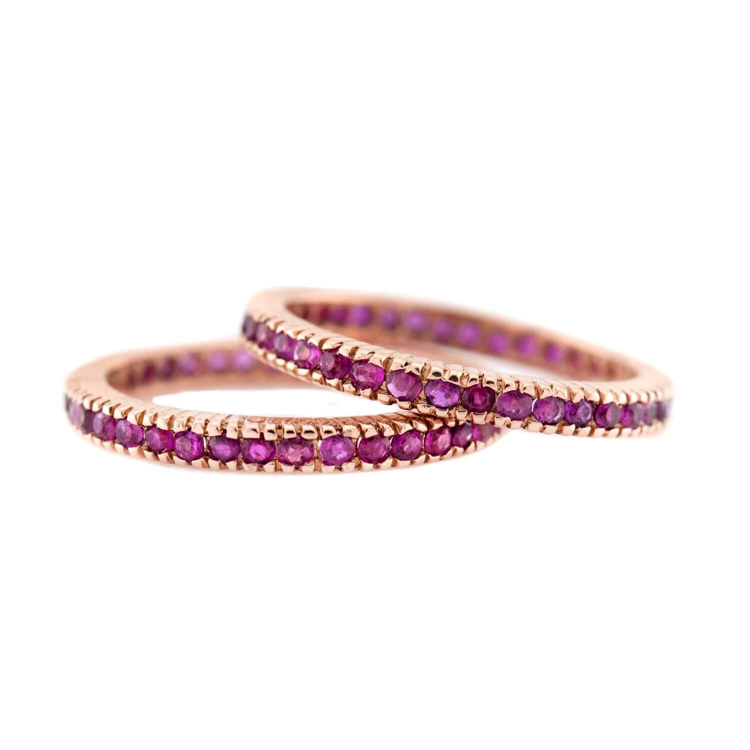 Uno splendido set di fedi eternità con rubino! Realizzate in oro rosa 14 carati, queste fedi abbinate presentano una linea centrale di rubini a taglio rotondo, che mostrano una profonda tonalità rossa e sono racchiusi in perline. Insieme, i rubini