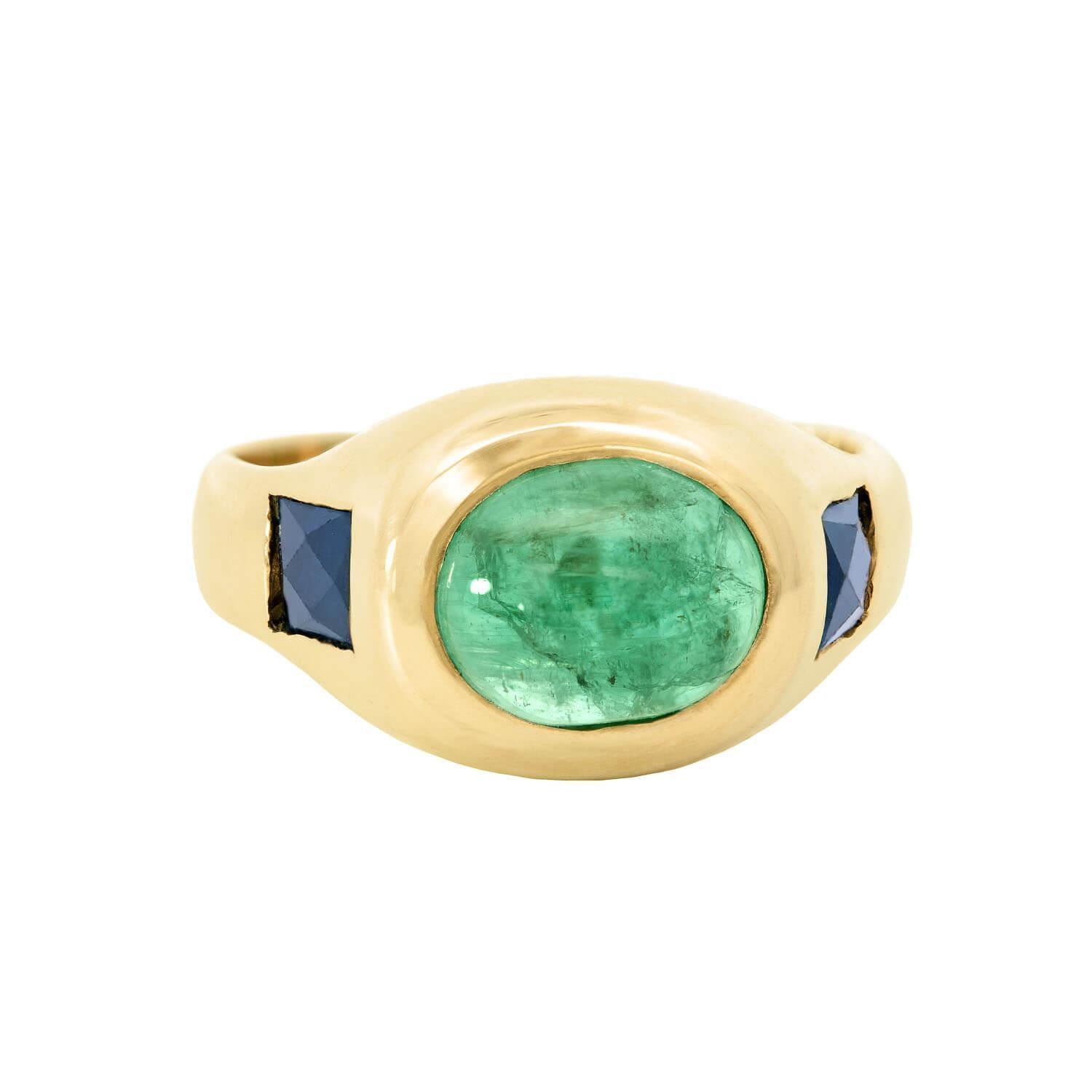 A beautiful Estate emerald and sapphire ring! This stunning piece is made of 14k gold and has 3 gorgeous stones that rest in flush mountings organized horizontally across the top of the ring. The center stone is a stunning 1.75ct emerald cabochon,