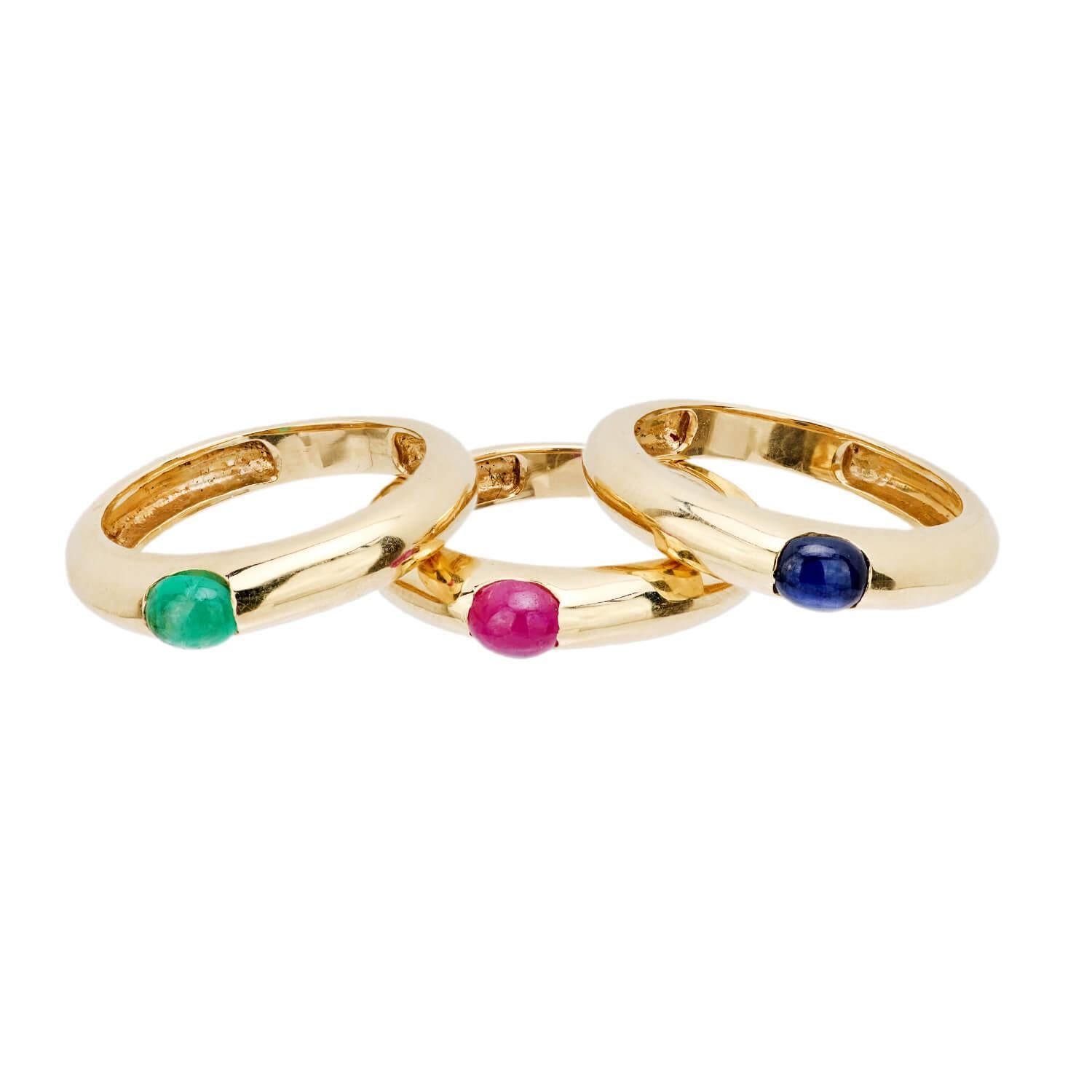 Ein fabelhaftes Paar Nachlass-Goldbänder! Diese zusammenpassenden Ringe sind aus 14 Karat Gelbgold gefertigt und weisen jeweils einen anderen, unsichtbar gefassten farbigen Cabochon auf. Ein Band ist mit einem Rubin, ein anderes mit einem Smaragd