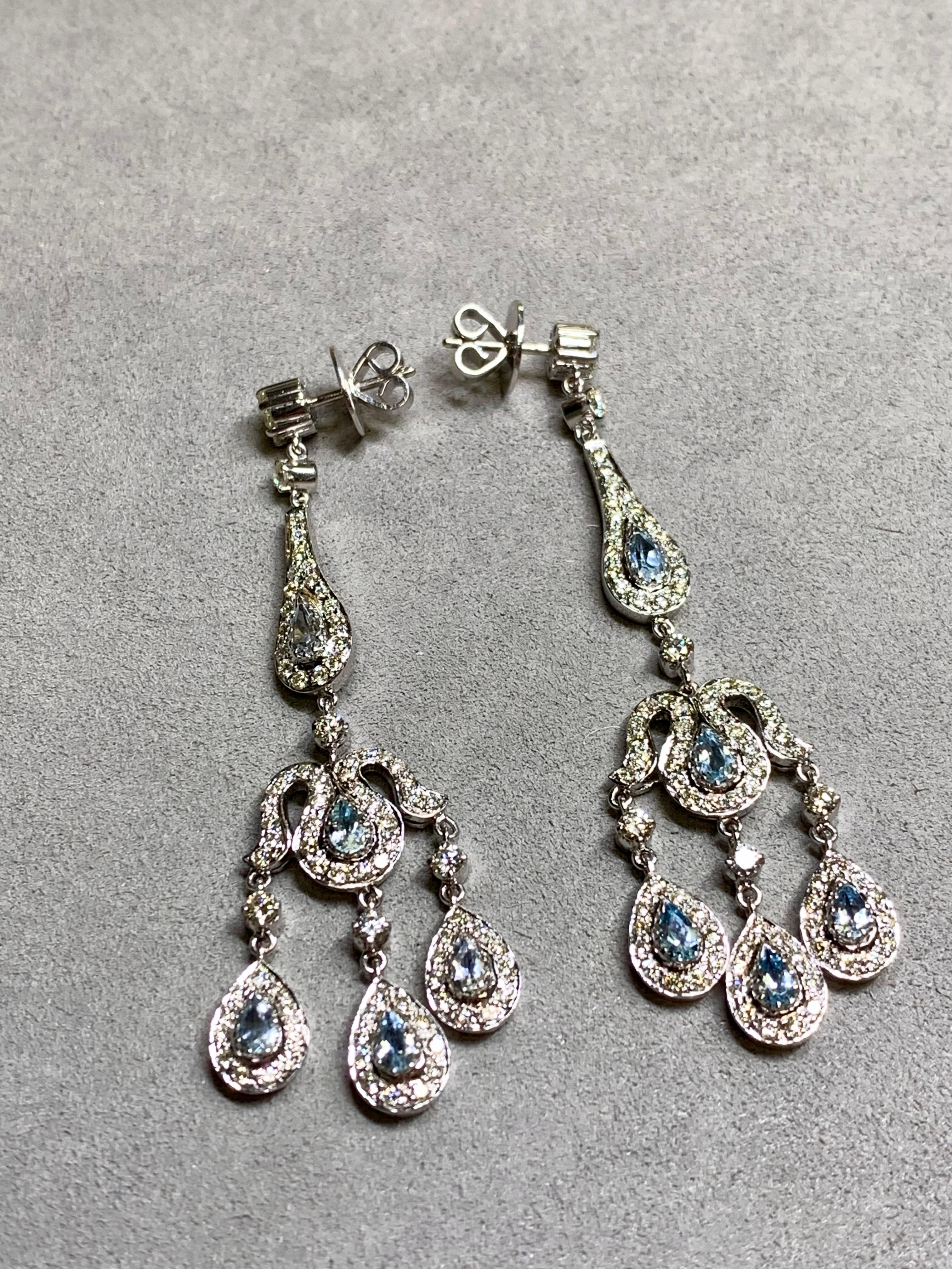 Una coppia elegante e scenografica di lampadari a goccia in oro bianco 14 carati con circa 3,20 carati di diamanti rotondi di colore H. H-J e purezza Vs2-Si1 e 2 carati di acquamarine naturali a forma di pera. Questi orecchini sono dotati di perni