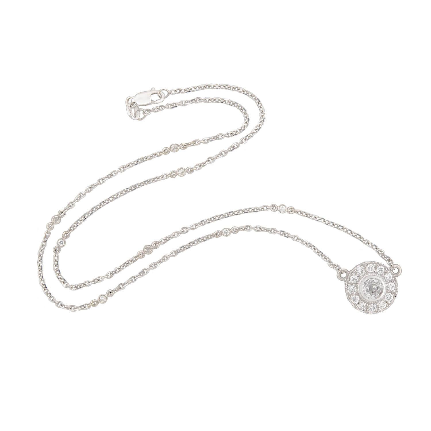 Un magnifique collier à pendentif en diamants de succession ! Réalisée en or blanc 14k, cette magnifique pièce se compose d'un pendentif circulaire étincelant serti d'un diamant de taille européenne ancienne d'environ 0,60ct, affichant une couleur H