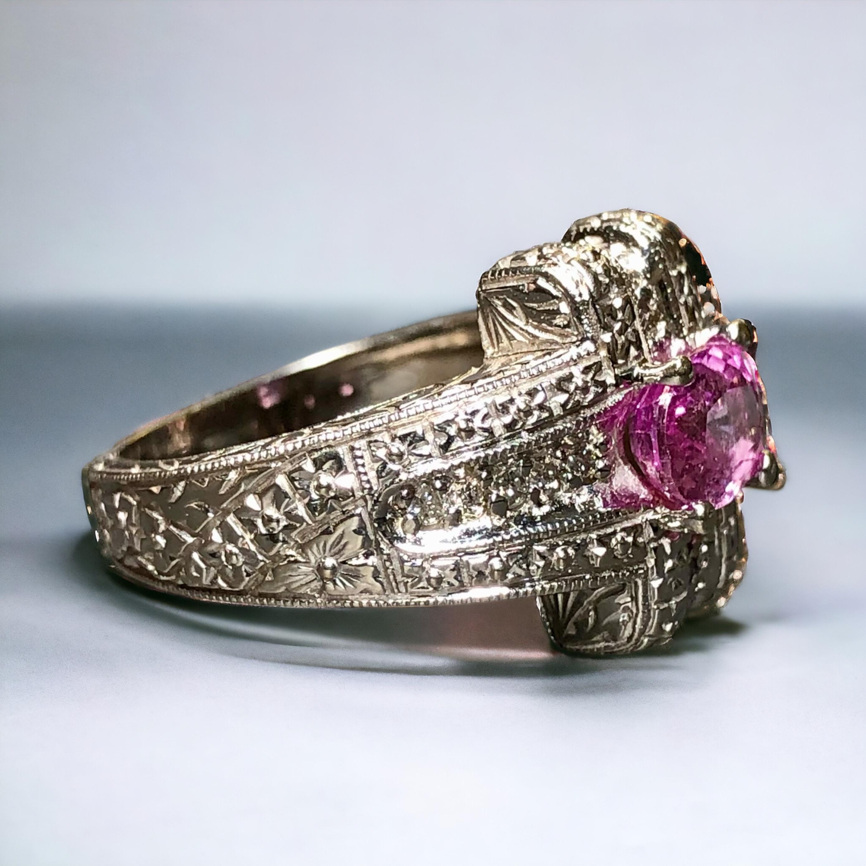 Un anello da cocktail contemporaneo di ottima fattura, realizzato in oro bianco 14K splendidamente filigranato e incastonato con circa 0,20cttw di diamanti rotondi di colore I-J e purezza Si1-2 e centrato da uno zaffiro rosa naturale di circa 1,70ct