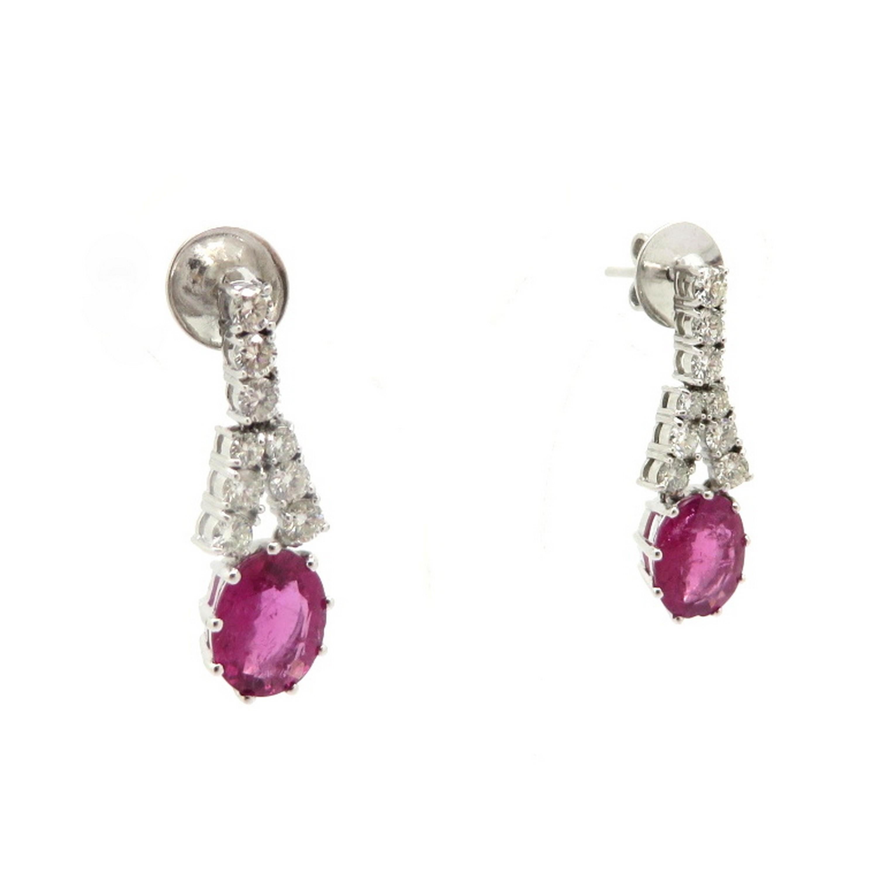 Estate 14K white gold pink tourmaline and round diamond dangle earrings. Showcasing two fine quality oval brilliant cut pink tourmaline gemstones, each nine prong set, weighing a combined total of approximately 3.36 carats. Accented with 18 round