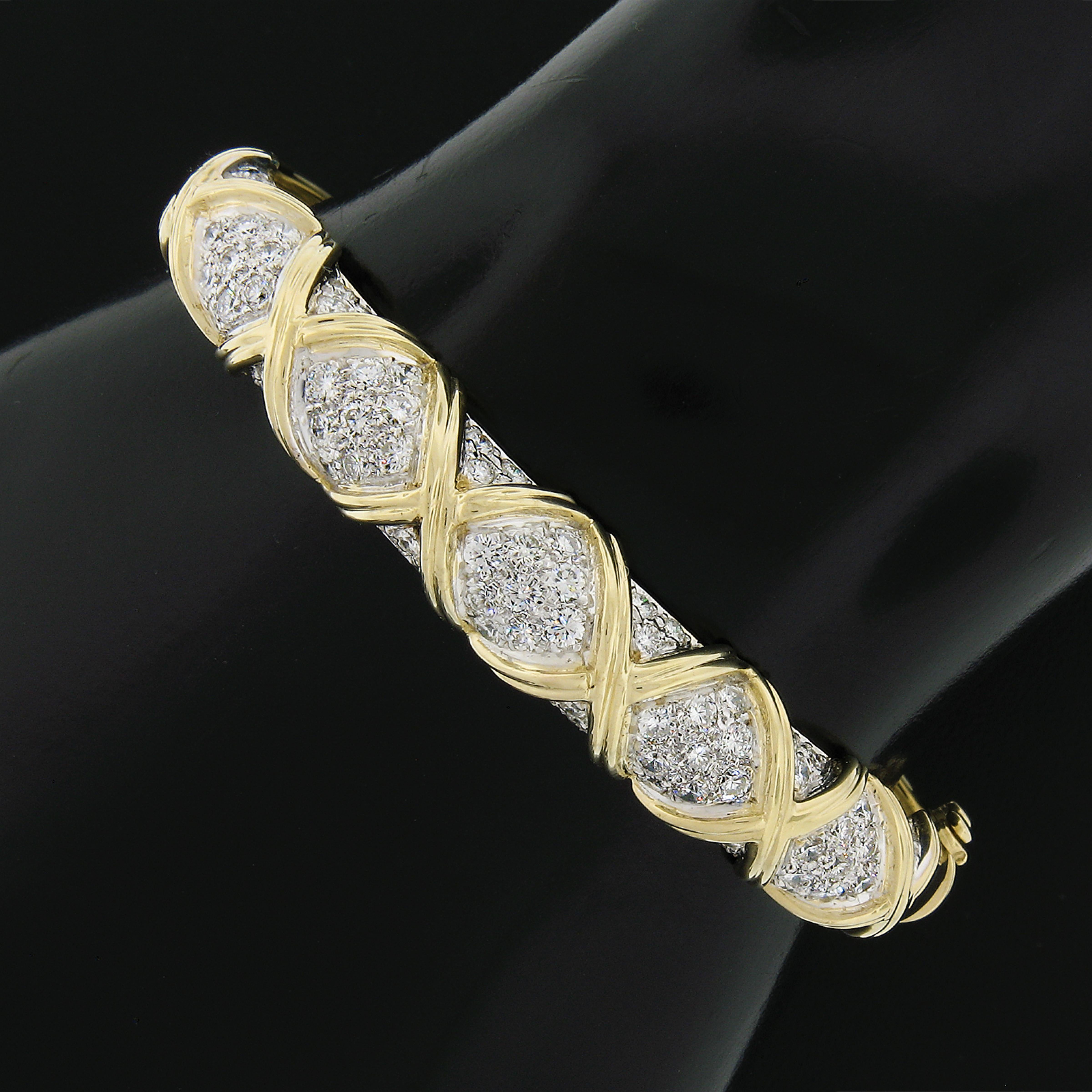 This gorgeous and very well made diamond bangle bracelet is crafted in solid 14k yellow and features a lovely figure X design set in sections with approximately 2.65 carats of very fine quality diamonds. The diamonds display amazing amount of fire