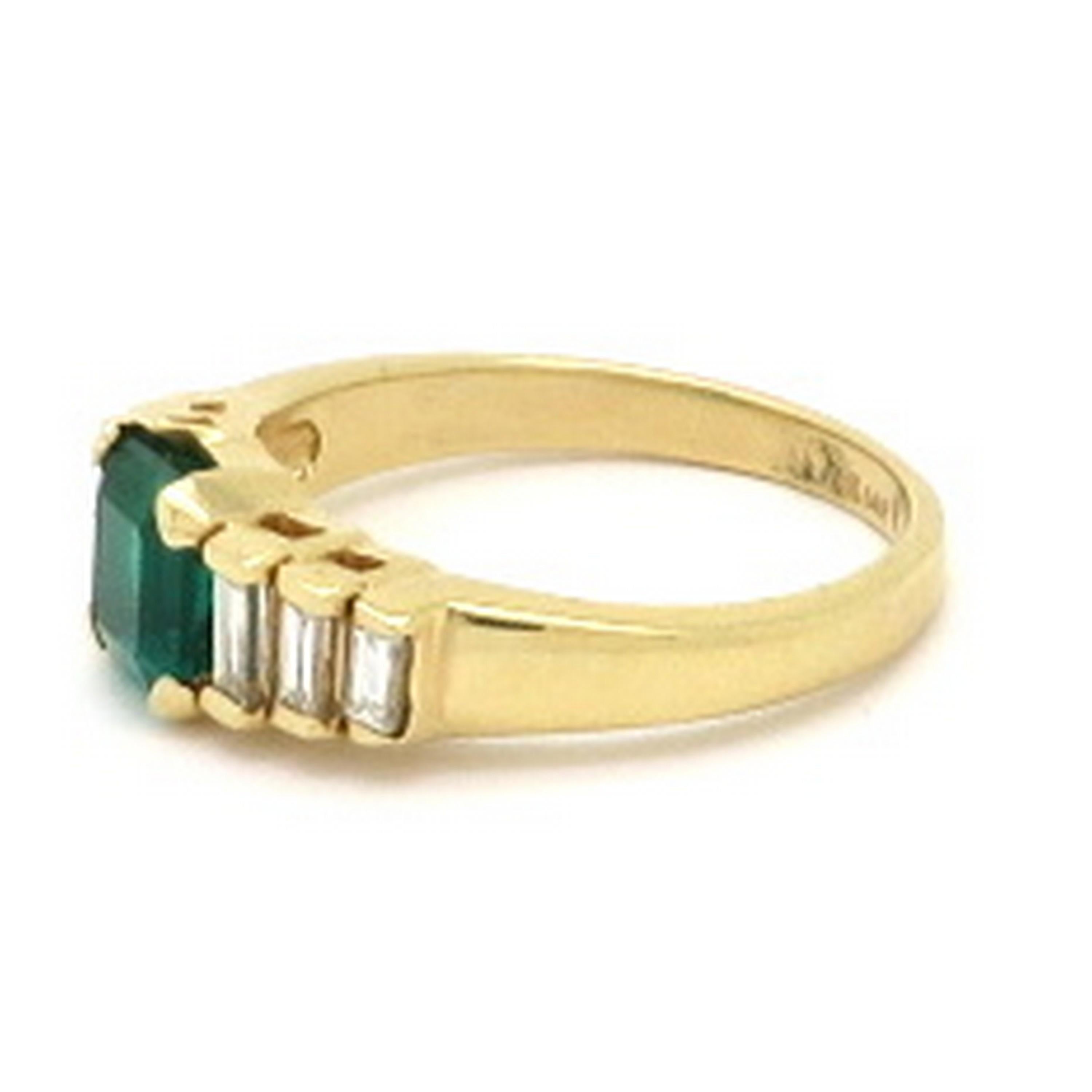 Estate 14K yellow gold AGL emerald cut Columbian emerald and baguette diamond ring. Showcasing one emerald cut fine quality AGL certified emerald, four prong set, weighing approximately 1.20 carats. Flanking the center stone are six channel set