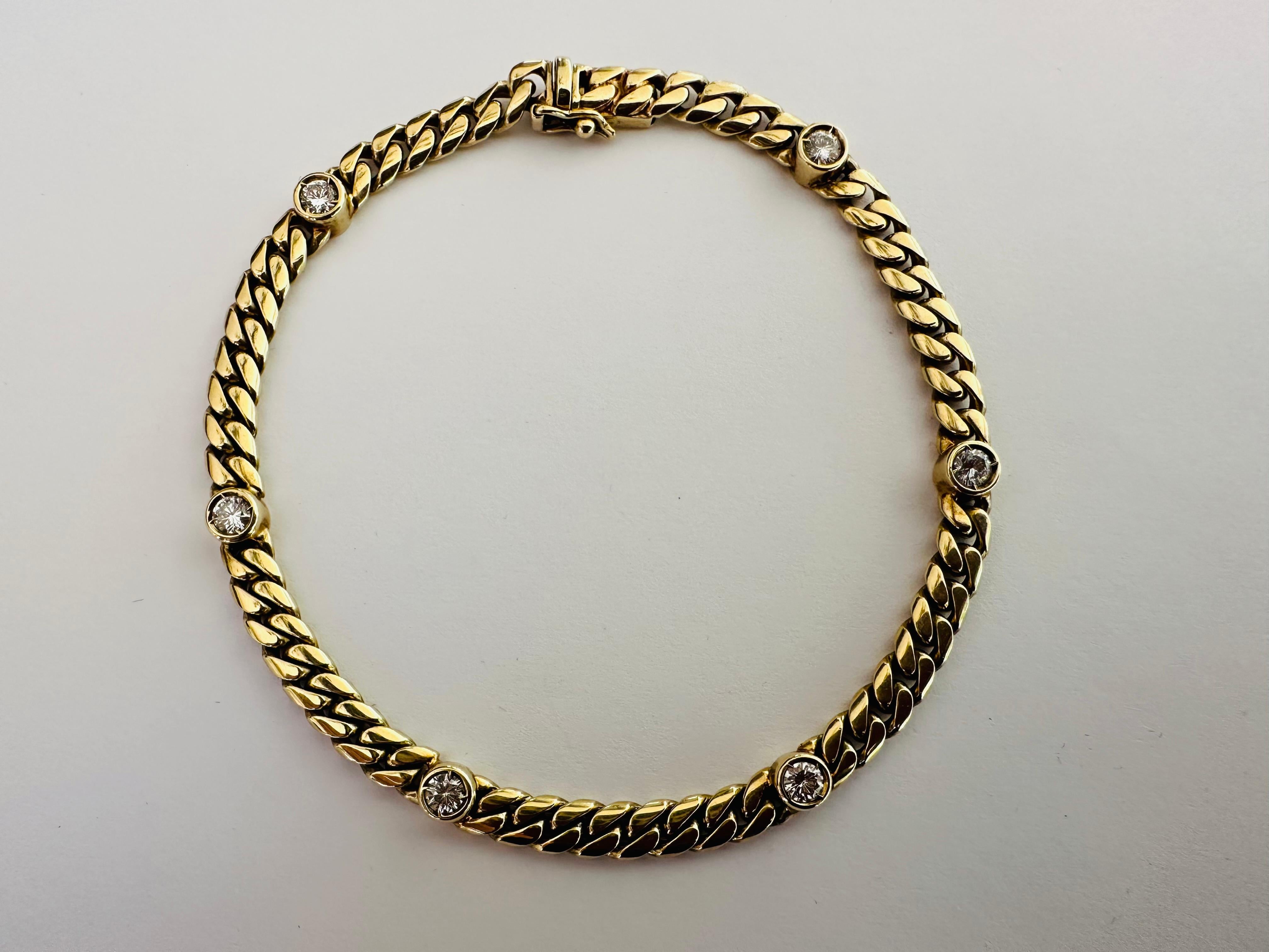 Six round bezel-set diamonds totaling approximately 0.90 carat, GH color VS-SI clarity, shine from 
within this Cuban link bracelet crafted in 14K yellow gold. The bracelet measures 7.75