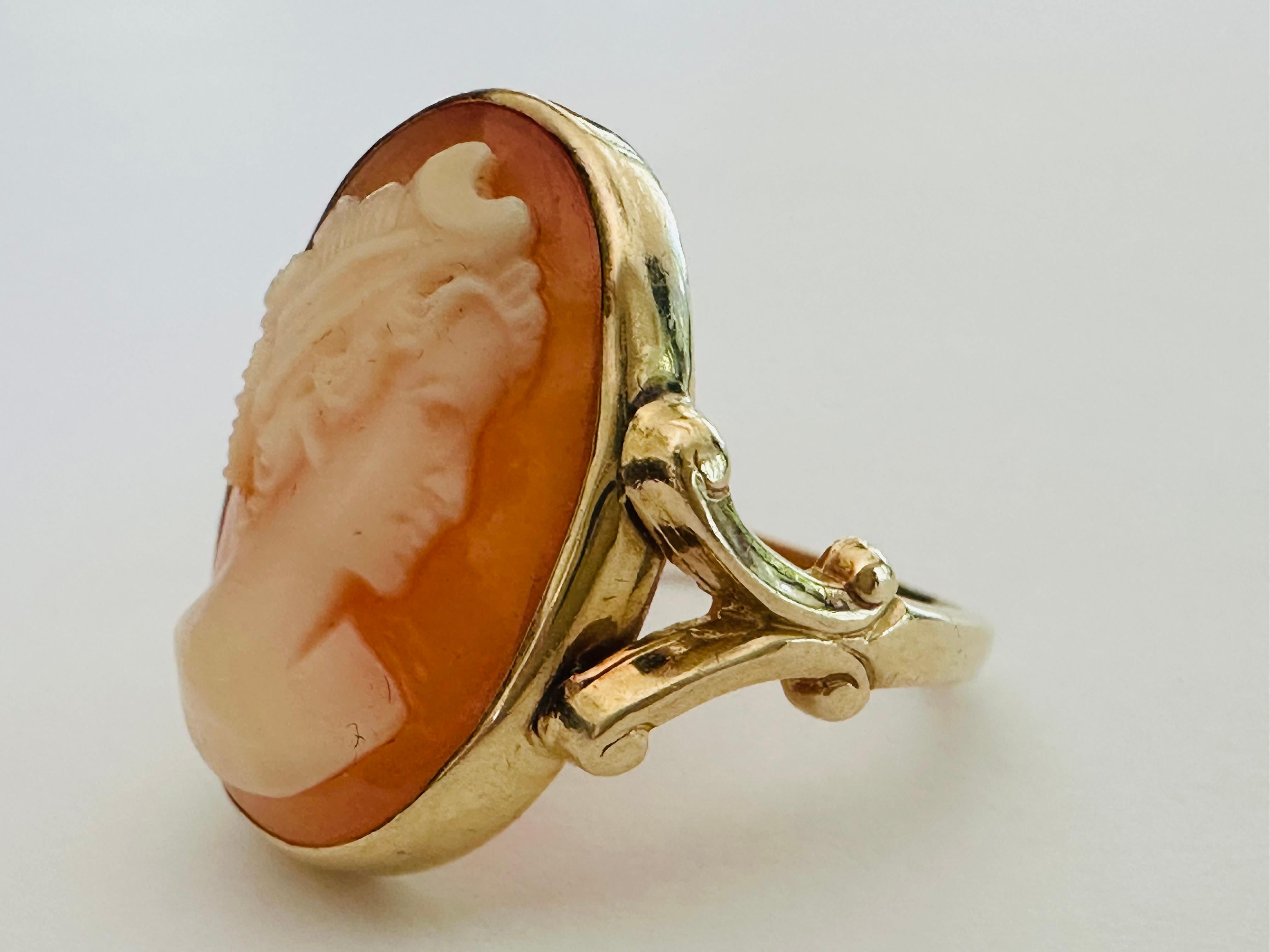 Diese Estate Vintage Split Shank Gold und Shell Kamee Ring verfügt über eine schöne Dame im Profil meisterhaft geschnitzt Messung 20x15mm und vor einem weichen rosa-orange Hintergrund präsentiert. Aus 14-karätigem Gelbgold und mit Fleur de