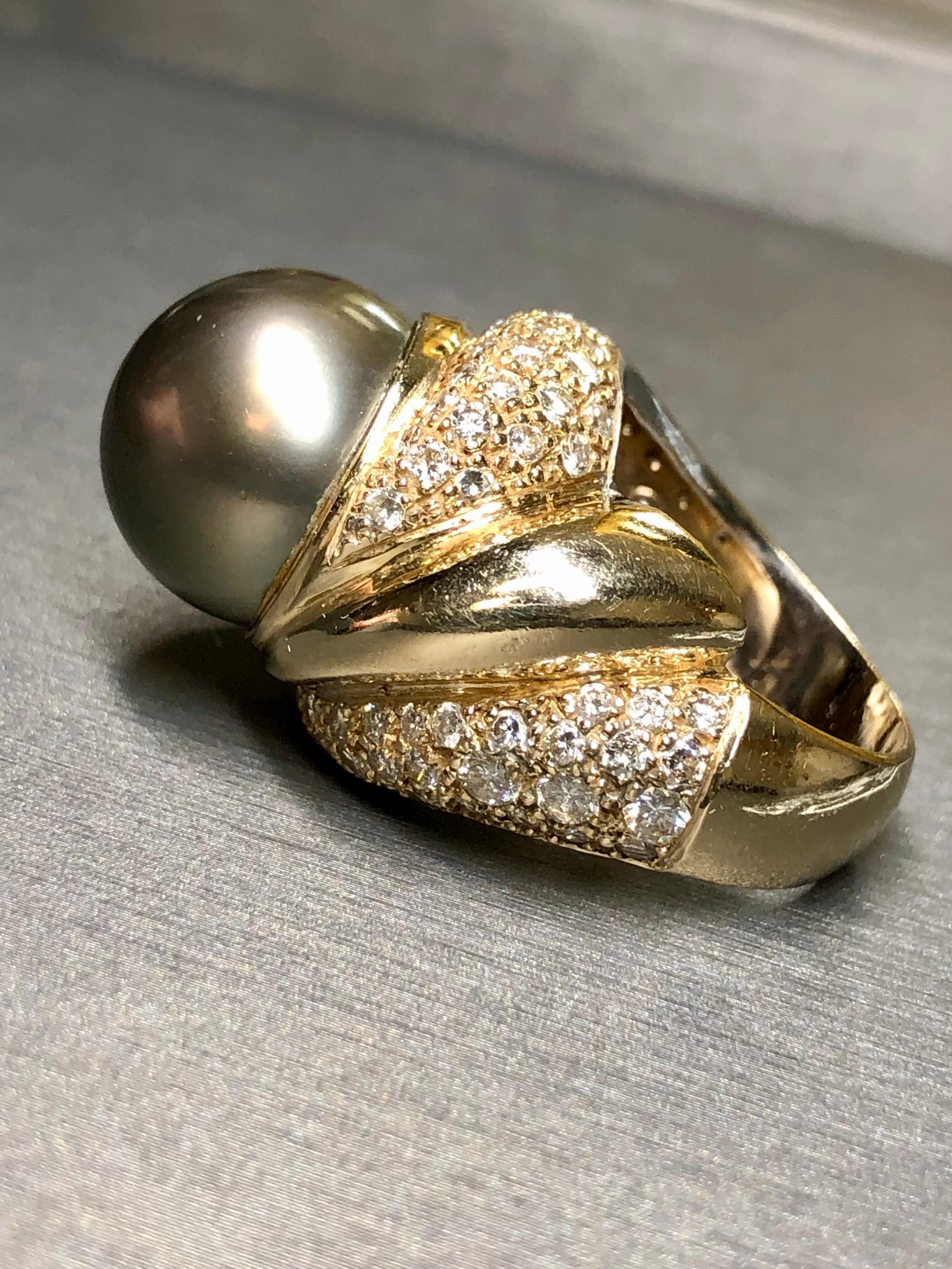 Une bague de cocktail plus large en or jaune 14 carats centrée sur une perle de Tahiti de 15,40 mm. Comme vous pouvez le constater, il présente un éclat magnifique et peu ou pas de piqûres en surface. Autour de la perle se trouve un diamant rond de