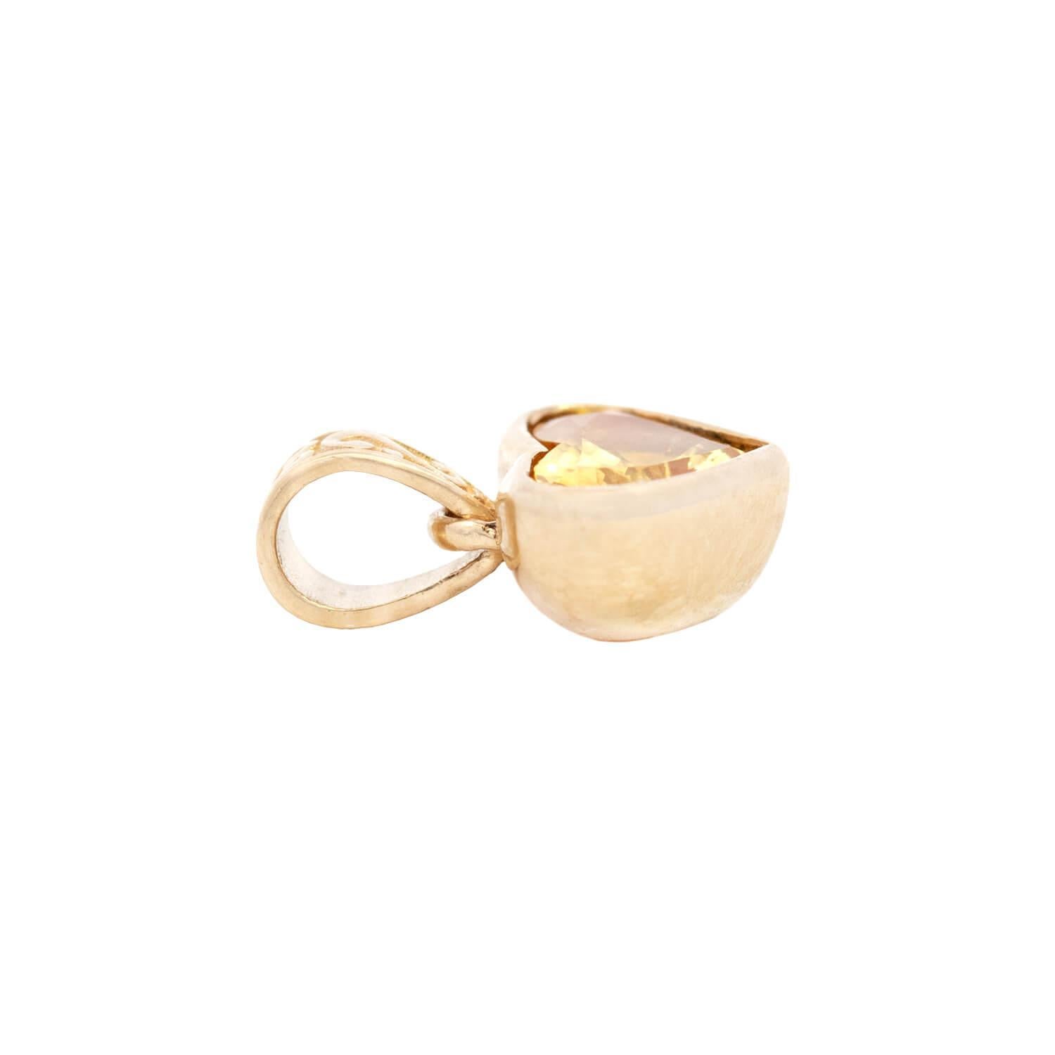 Un bellissimo ciondolo con zaffiro giallo! Realizzato in oro giallo 14 carati, questo splendido pezzo ha la forma di un cuore di piccole dimensioni, con una pietra centrale di zaffiro giallo tagliato a cuore. Lo zaffiro da 1,20 carati incastonato