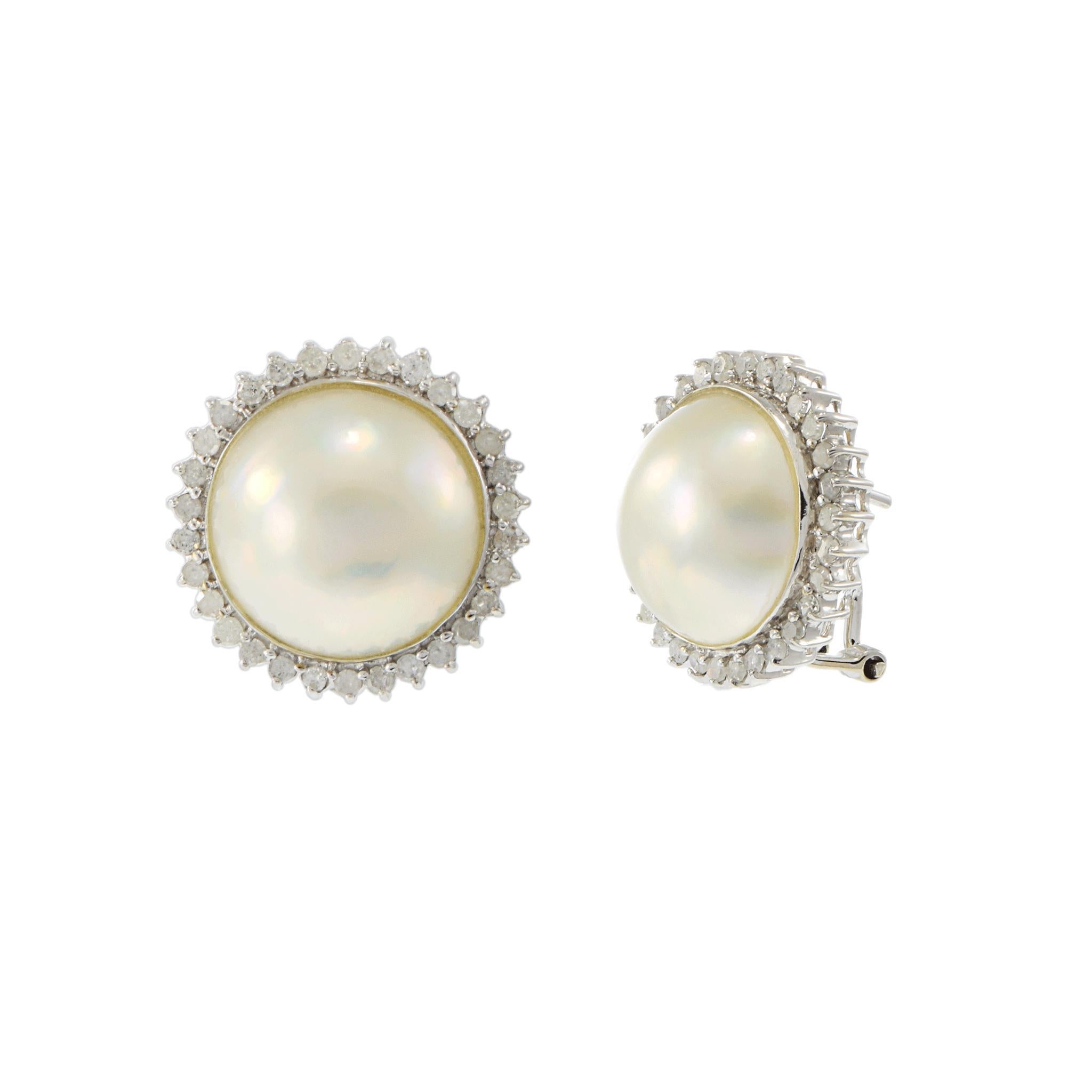 Estos pendientes de herencia combinan la elegancia clásica con un suave brillo. En el centro de cada uno hay una perla mobe de 13 mm, suavemente abombada y engastada en brillante oro blanco de 14 quilates. Un halo de diamantes brillantes redondos
