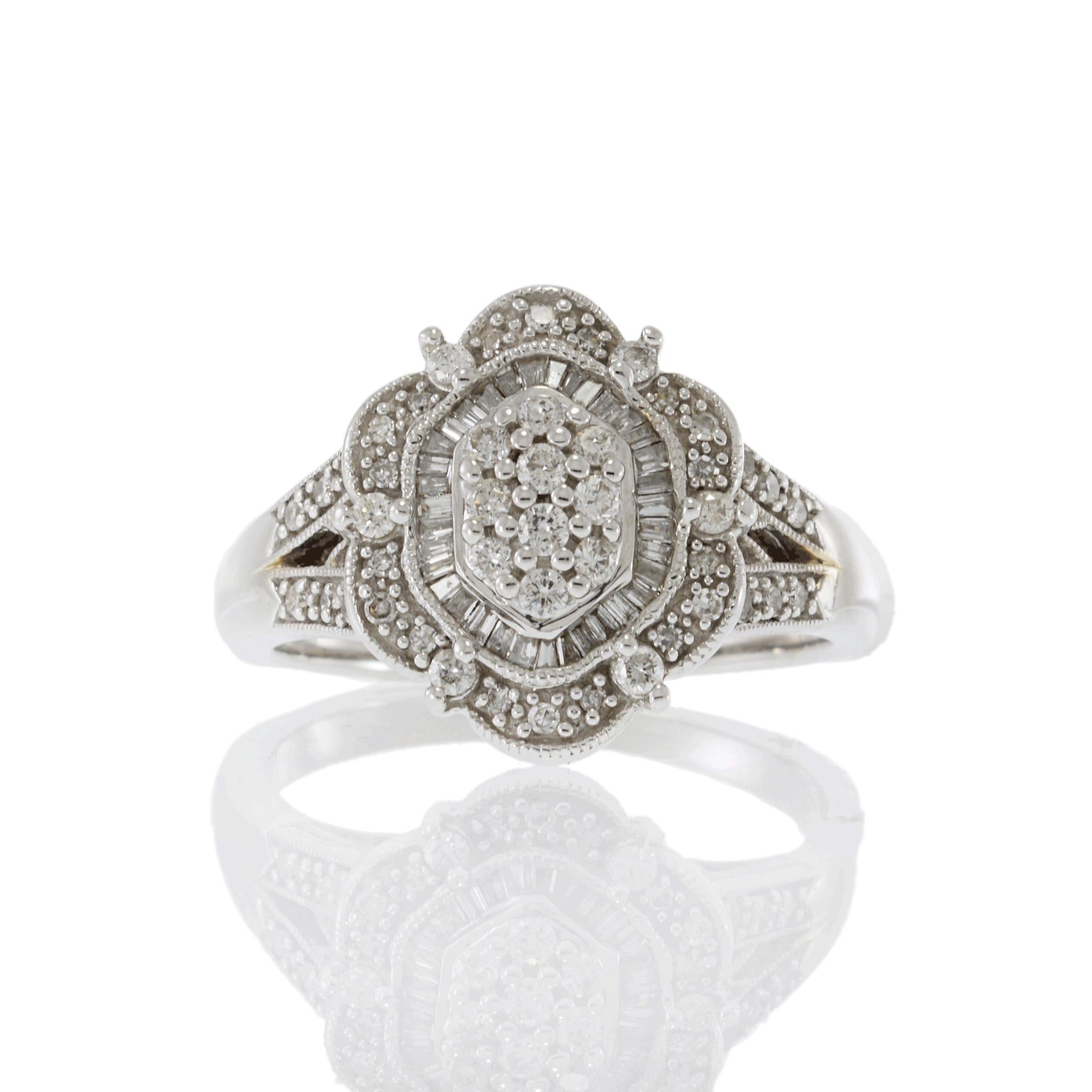 Elegante anello con diamante in oro bianco 14k in stile Art Deco. Questo squisito anello è realizzato in oro bianco 14k. Il centro presenta uno splendido diamante rotondo, circondato da un'aureola di diamanti con taglio a baguette. Il design