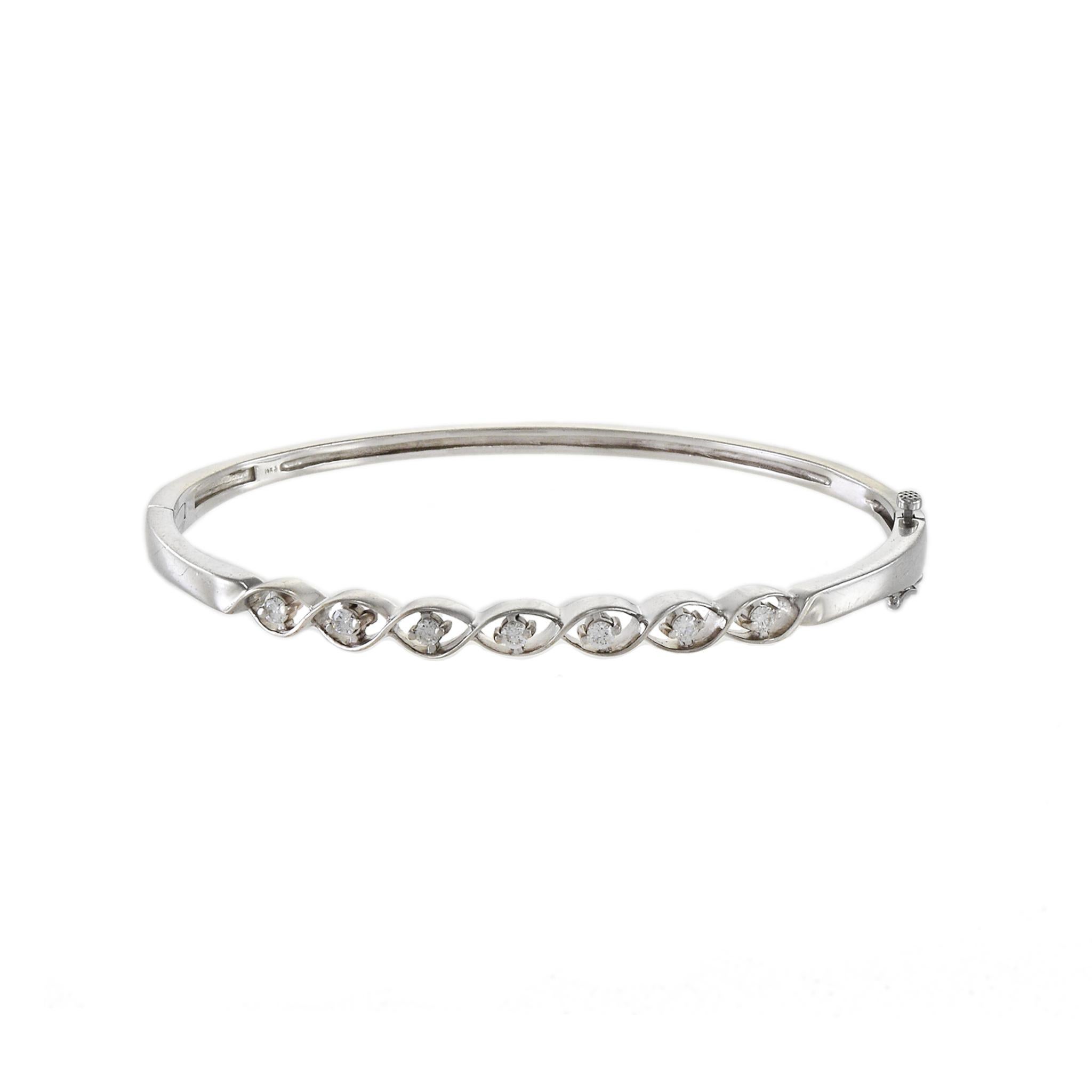 Estate 14KT White Gold Diamond Swirl Bangle Bracelet. Contient 0.35ct-tw round brilliant cut diamonds. 11.40 Grammes