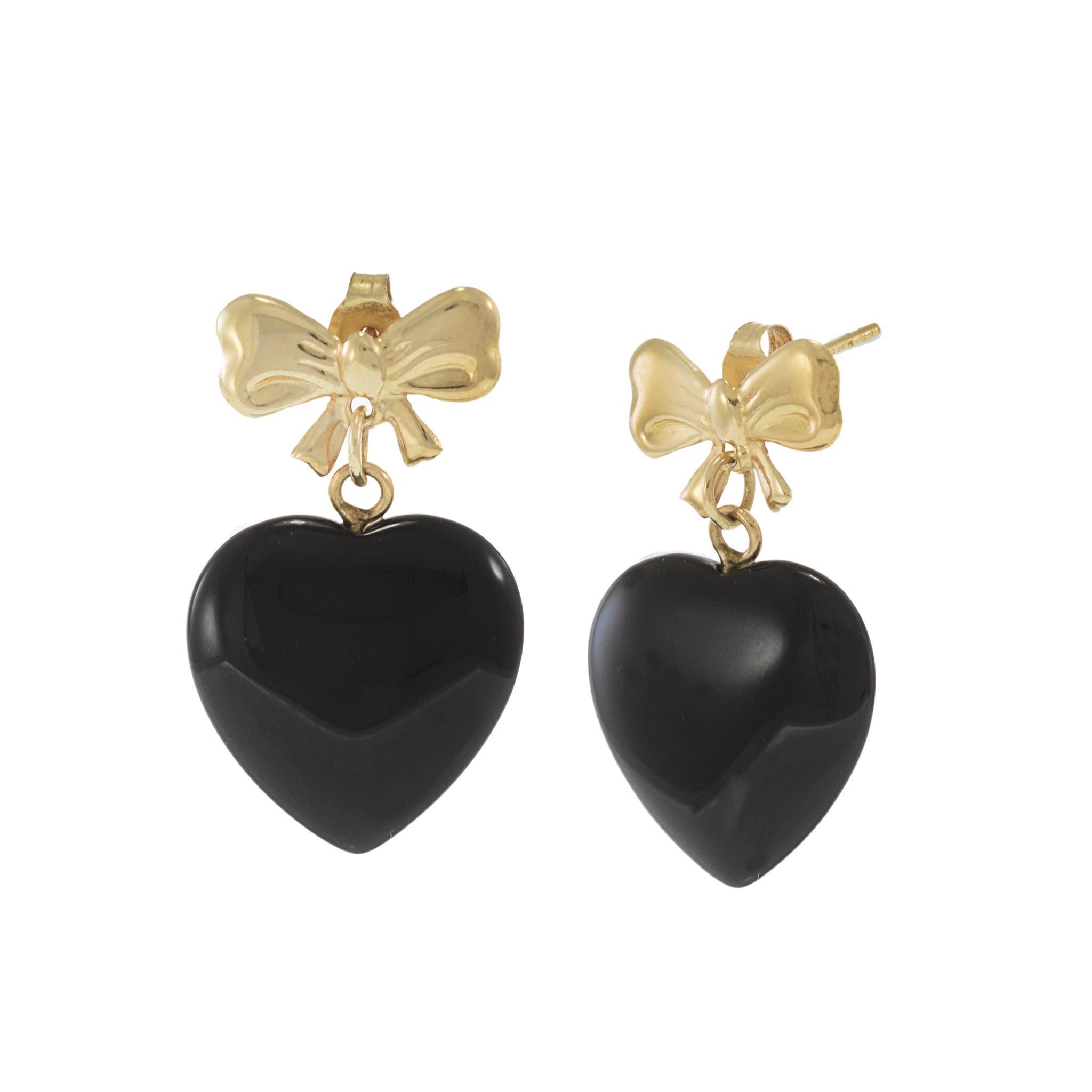 Dolcemente nostalgici con un pizzico di glamour audace, questi orecchini di proprietà fondono romanticismo giocoso e fascino vintage. Realizzato in oro giallo 14KT, ogni orecchino presenta un fiocco lucido da cui pende un cuore scolpito in onice