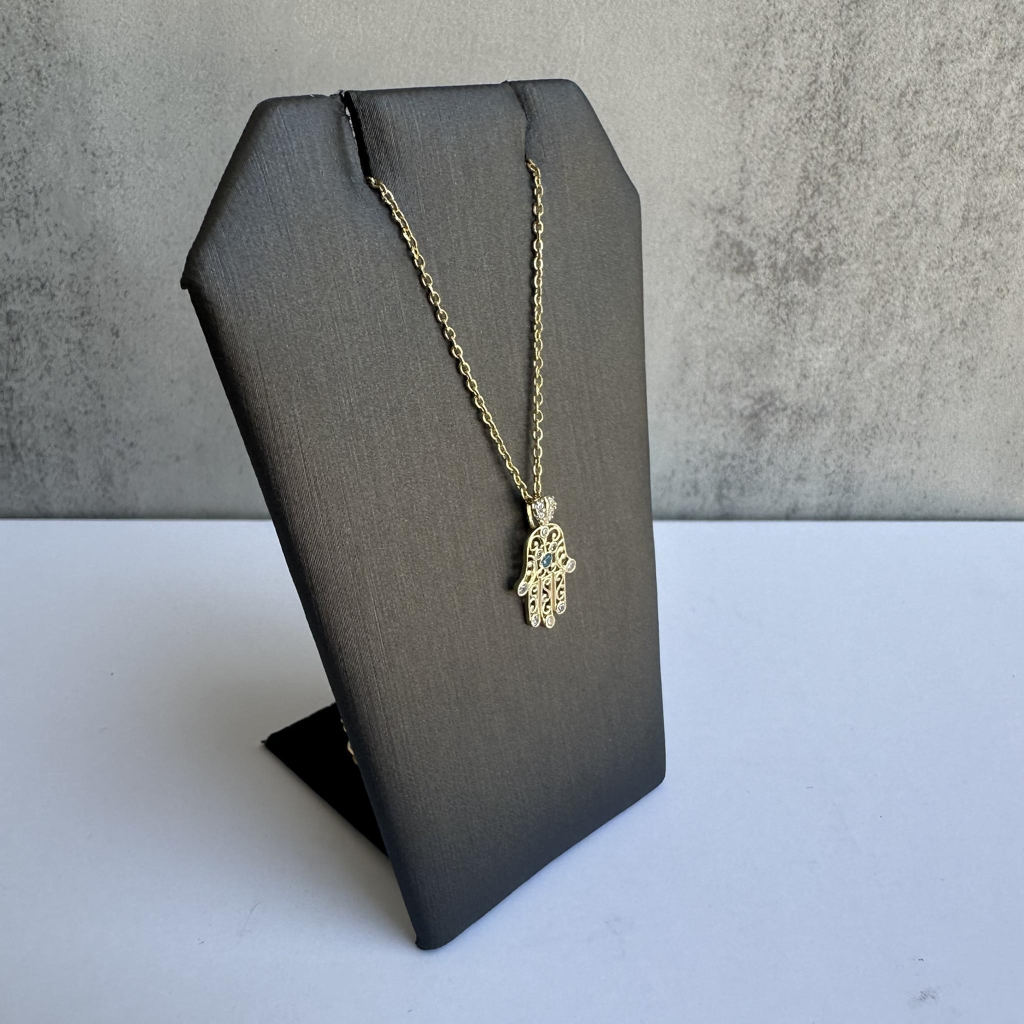 Add a touch of symbolism and elegance to your jewelry collection with this Estate Diamond and Zircon Hamsa Necklace in 14kt Yellow Gold. Featuring 0.06 carats total weight of GH SI natural round diamonds and a 0.02 carat blue zircon, this necklace