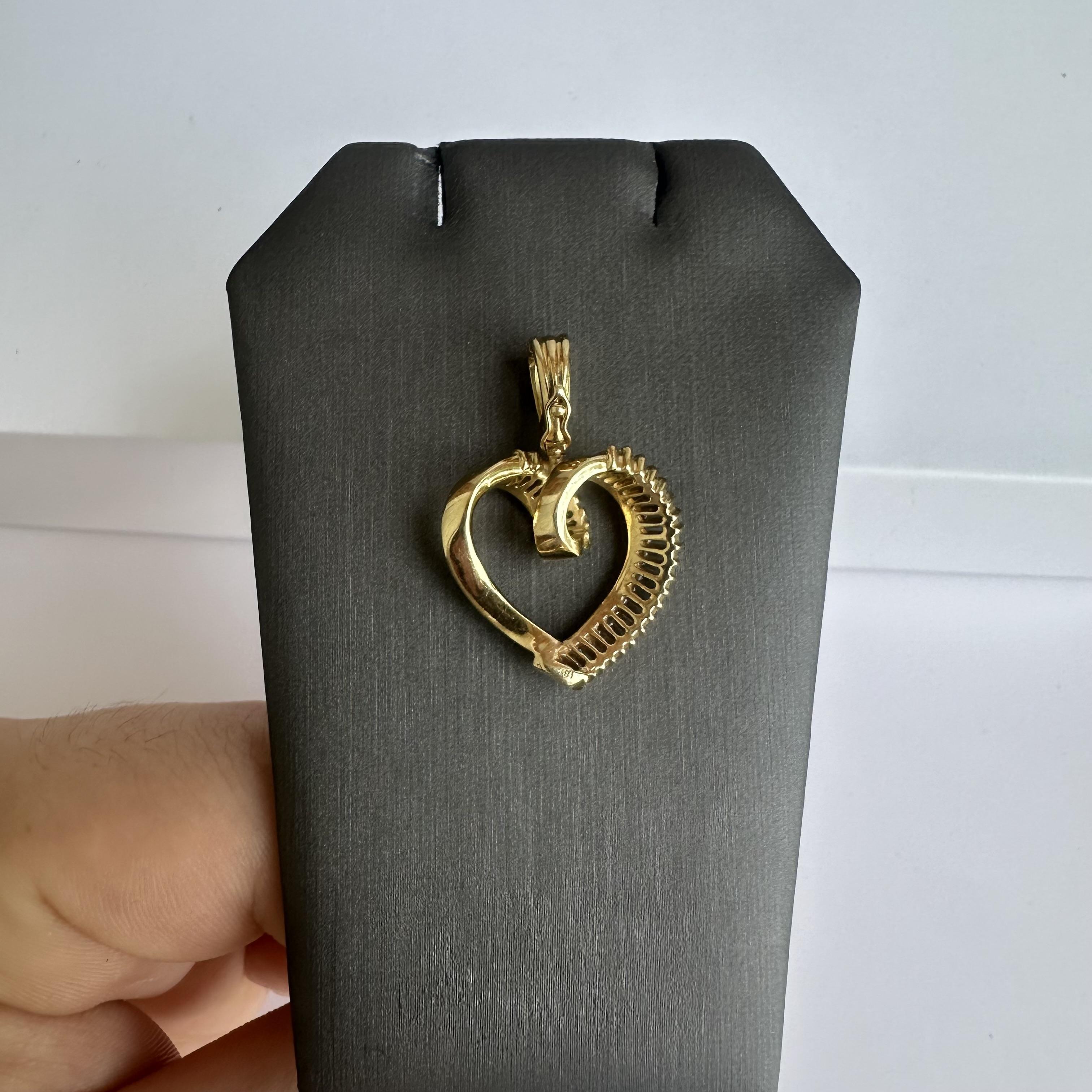 This exquisite Estate Diamond Heart Pendant in 14kt Yellow Gold is a timeless piece that embodies elegance and romance. Featuring 1.45 carats of HI SI eye-clean natural baguette cut diamonds, this pendant beautifully captures the light, adding a
