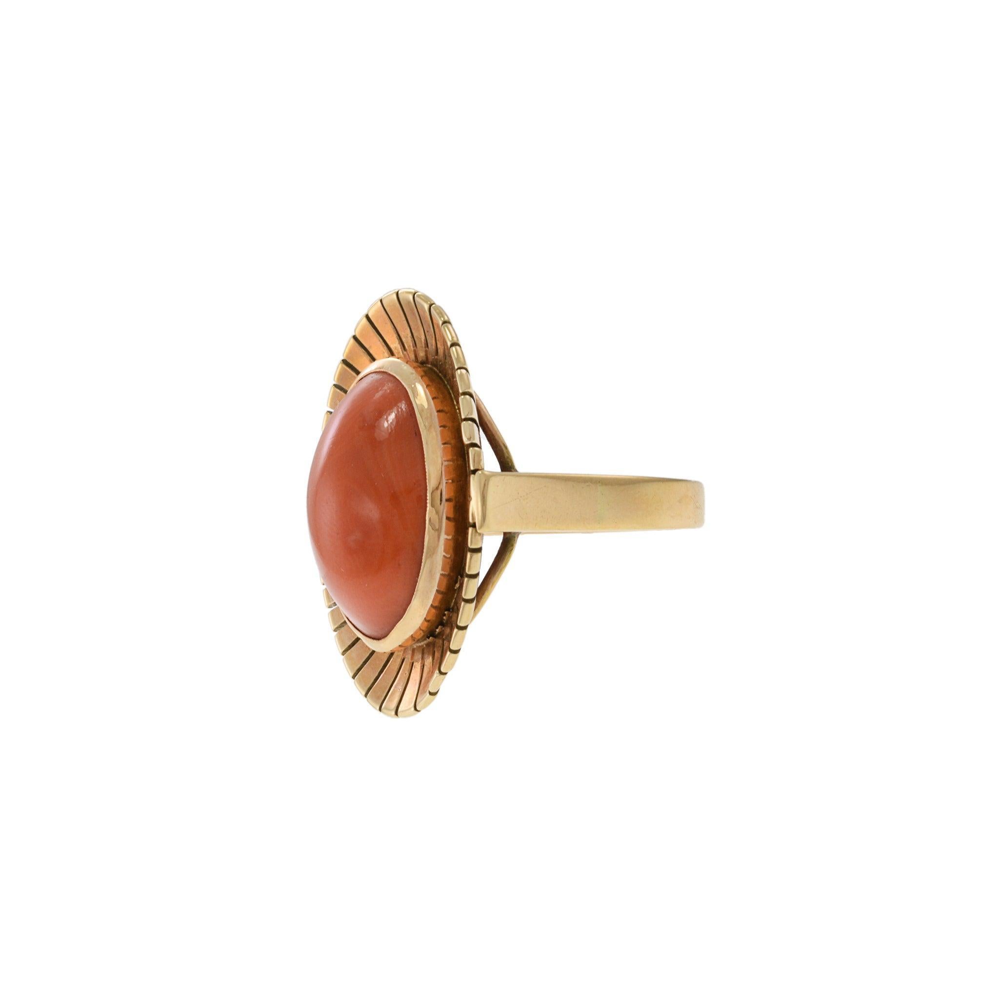Dieser Vintage-Ring zeigt einen natürlichen Korallen-Cabochon, der von einer 14-Karat-Gelbgold-Lünette im Sonnenschliff-Stil eingerahmt wird. Das geriffelte Design, das die reiche, warme Koralle in der Mitte umgibt, verleiht dem Stück einen