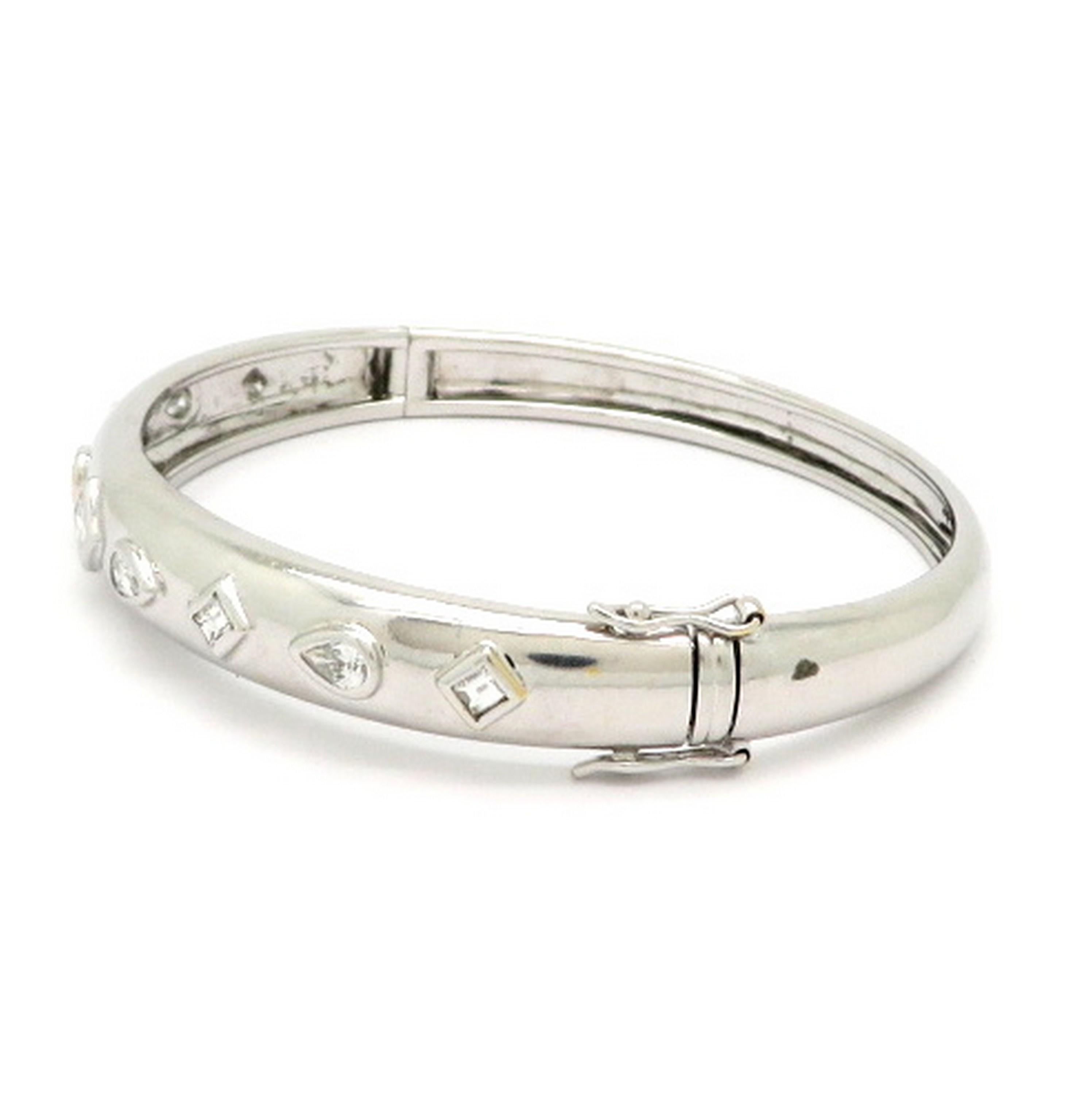 Estate 1.50 carat multi shape 18K white gold diamond bangle bracelet. Showcasing four emerald cut diamonds, four pear-shaped diamonds, and one princess cut diamond, with various measurements, weighing a combined total of approximately 1.50 carats.