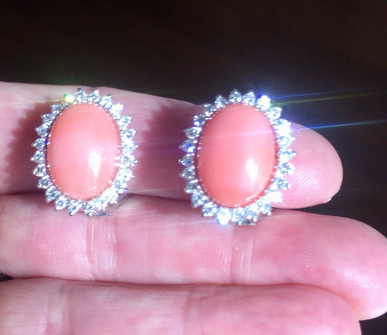 These gorgeous stud/drop earrings feature two salmon peach coral cabochons, each measuring measuring 16mm x 12mm and each set with a stunning halo of diamonds totaling 1.10 carats of G-H color and VS clarity.

The earrings measure 20m long by 17mm