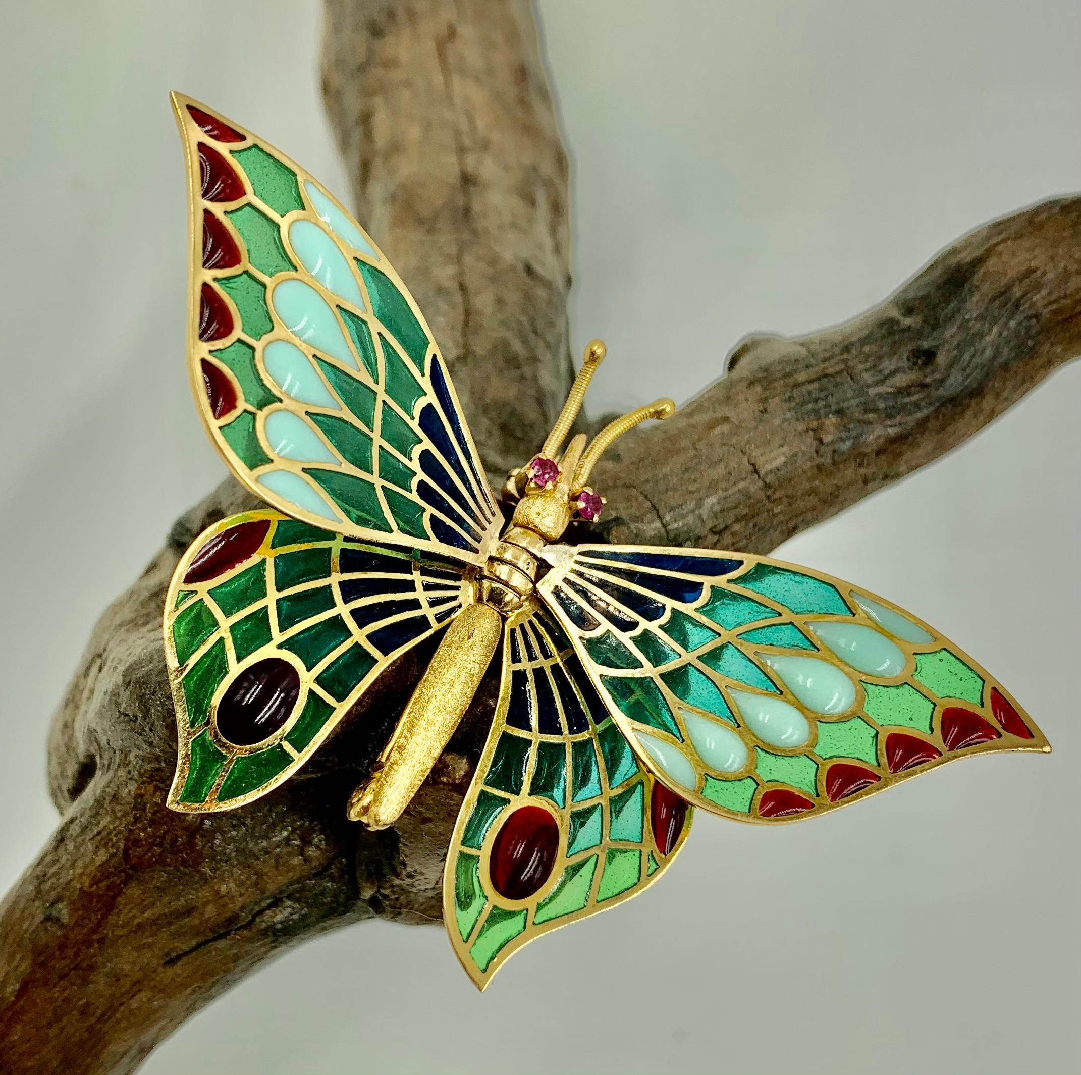 Beautiful 18 karat yellow gold and multi-colored jeweled plique-a-jour enamel butterfly brooch with fully articulated wings and ruby eyes. Finely chased antennae, faceted ruby eyes and textured body of this amazing butterfly form the support for
