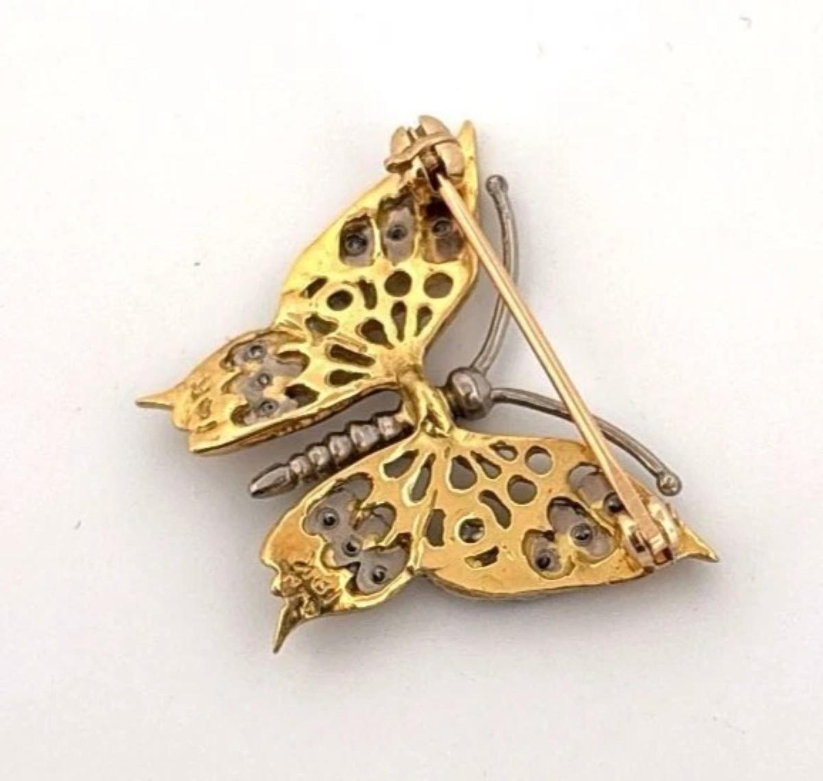 This vintage butterfly brooch is a beautifully handmade custom piece, crafted in a combination of 14K and 18K yellow gold with subtle white gold accents. The wings feature an intricate pierced design and are pavé set with approximately .20 carats