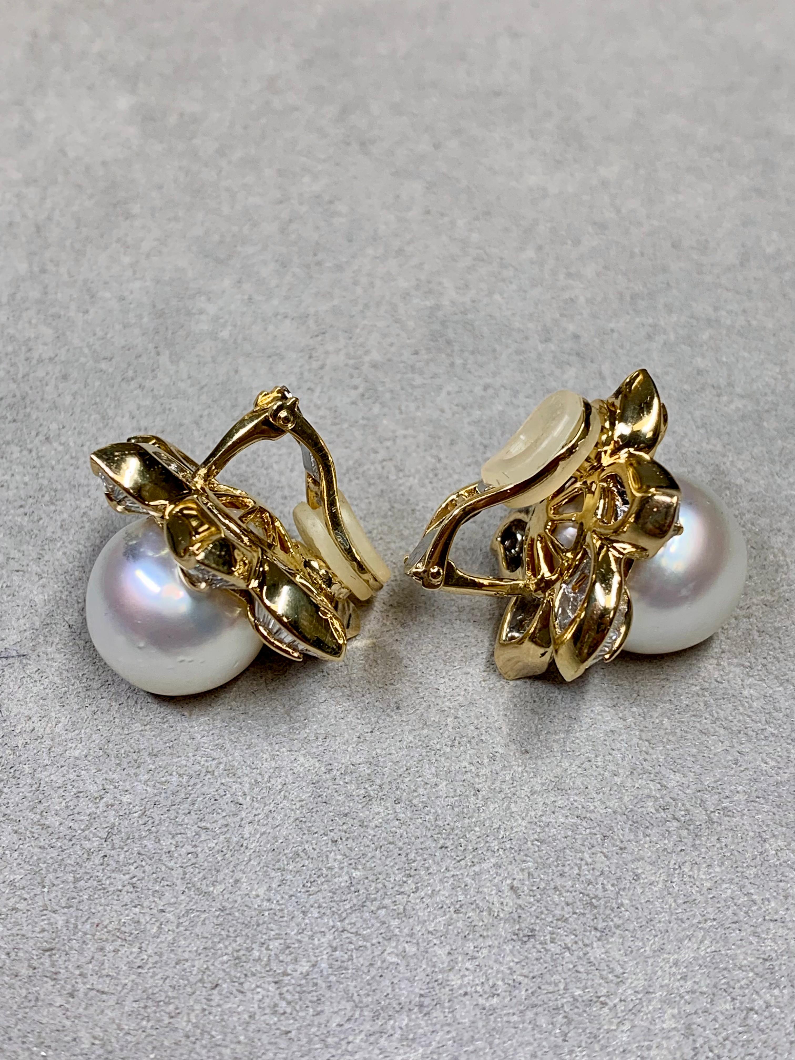 
A fabulous pair of ear clips crafted in 18K yellow gold and channel set with approximately 9ctw in tapered and square baguette cut diamonds averaging H-I color and Vs1-2 clarity. Centering each earring is an impressively large 14.75mm cream colored