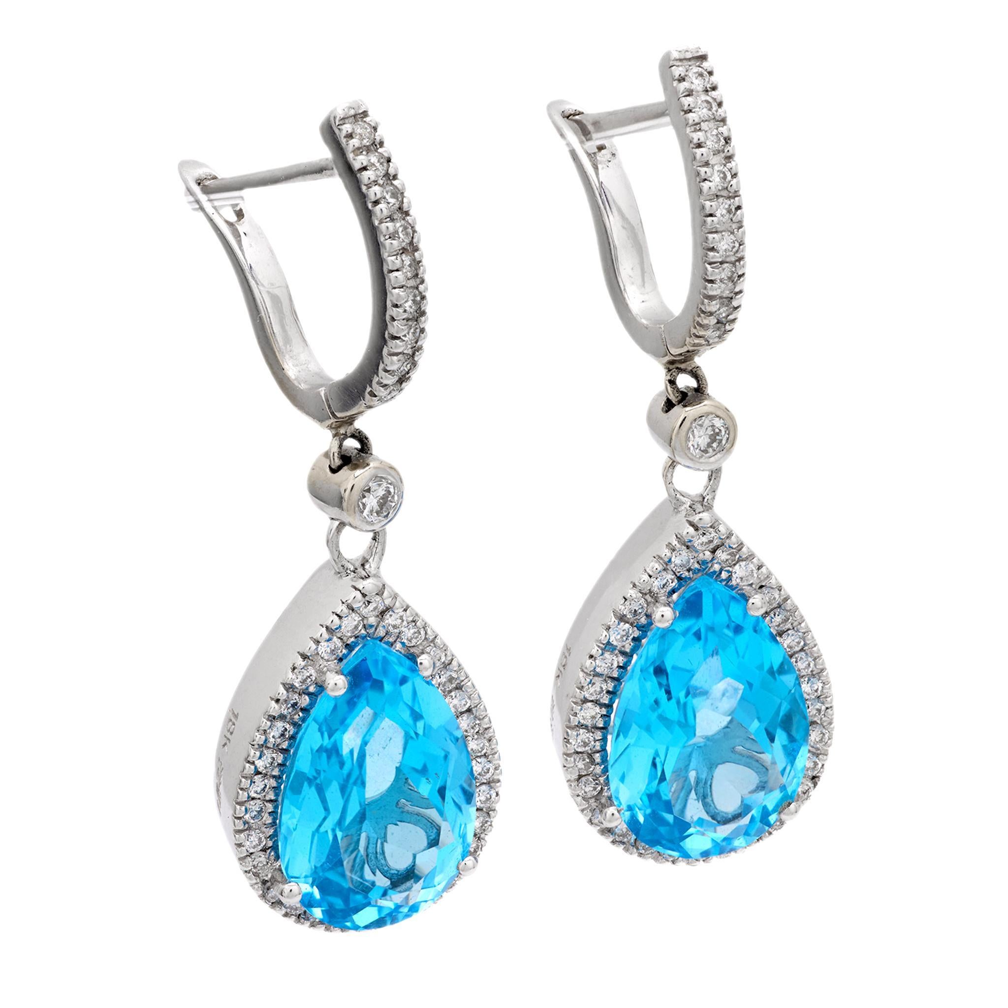 A lovely pair of topaz and diamond earrings! These fabulous earrings are crafted in 18k white gold and are comprised of a vibrant pear cut blue topaz stone. The topaz stones are held within four-prong settings, and display a breathtaking vibrant
