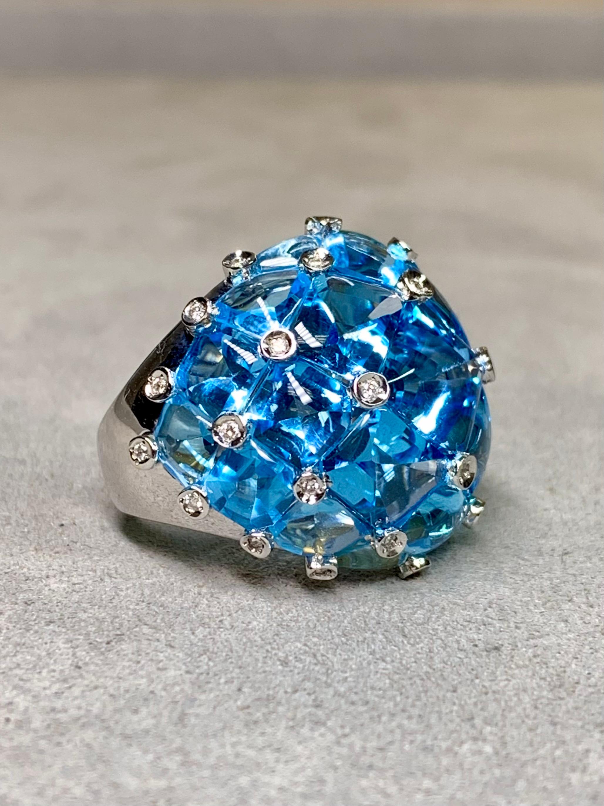Un anello da cocktail di eccezionale fattura, realizzato in oro bianco 18 carati e rifinito con un'incastonatura quasi misteriosa. È stato ricoperto da 24,50 carati di topazio blu naturale, con la parte superiore sfaccettata e la parte inferiore