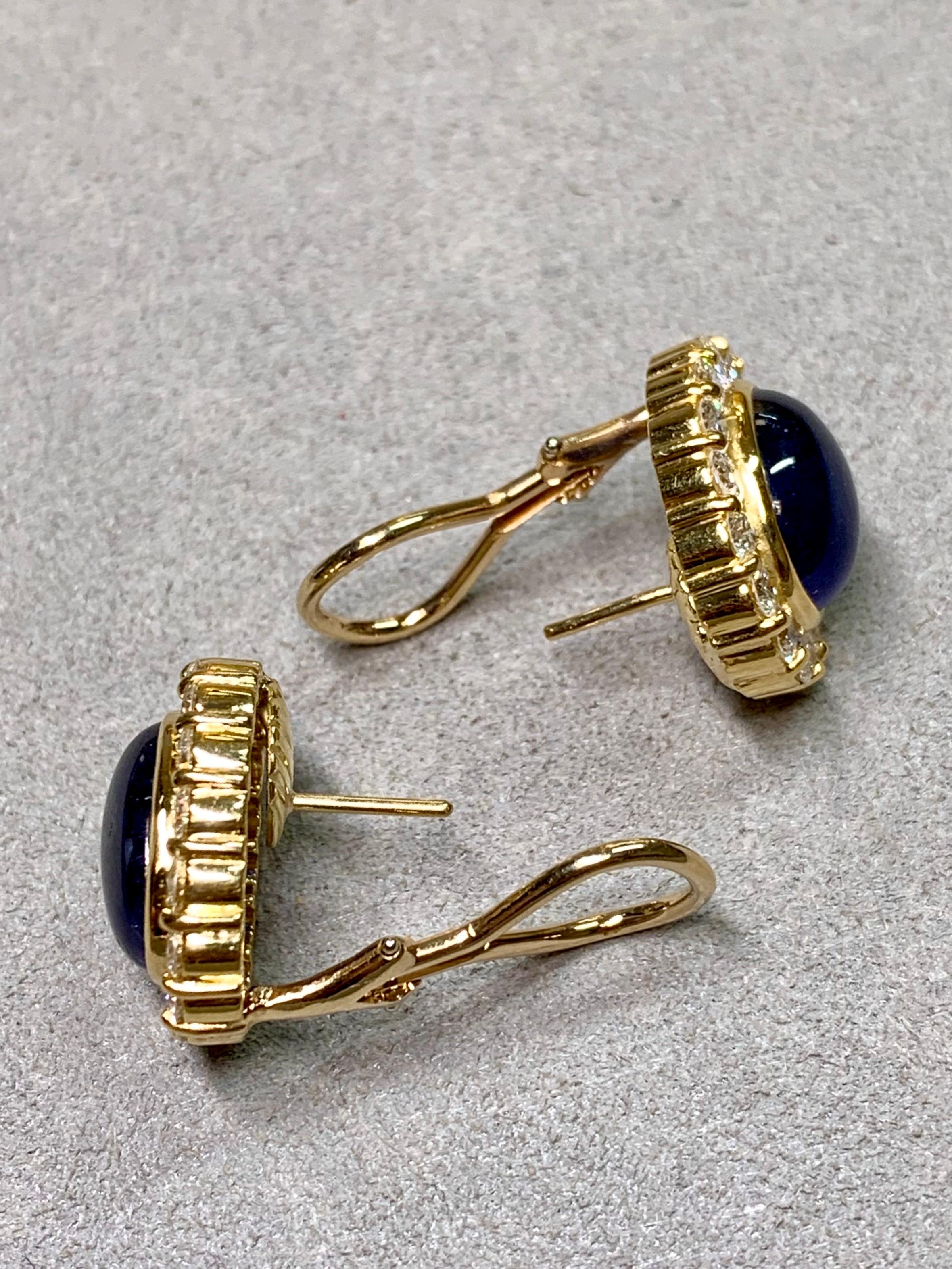 Classic and timeless, these impressive Rosetta-style earrings are crafted in rich 18K yellow gold. At the center of each rests a deep, velvety blue oval cabochon sapphire of remarkable presence, together weighing approximately 15 carats. The