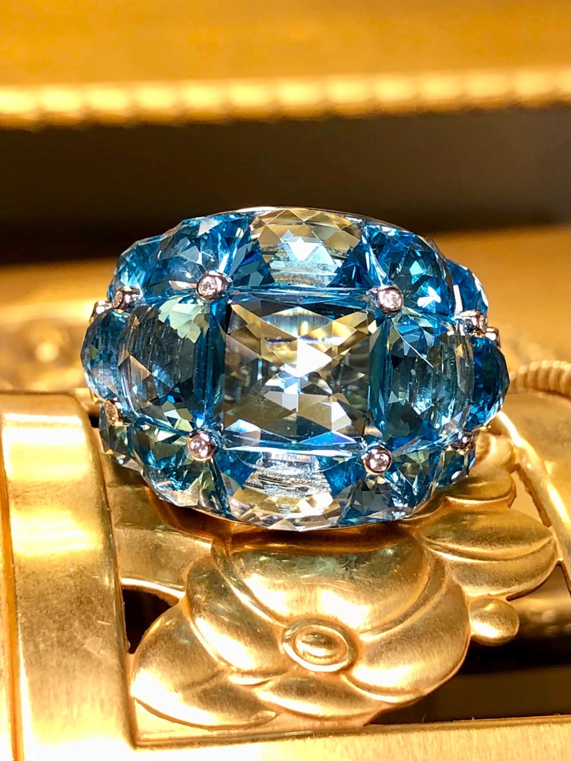 An absolutely spectacular ring hand made in 18K white gold and prong set with custom cut, calibrated natural deep blue topaz with a total approximate weight of 50cttw. Separating the stones are bezel set diamonds being G-H color and Vs1-2 clarity