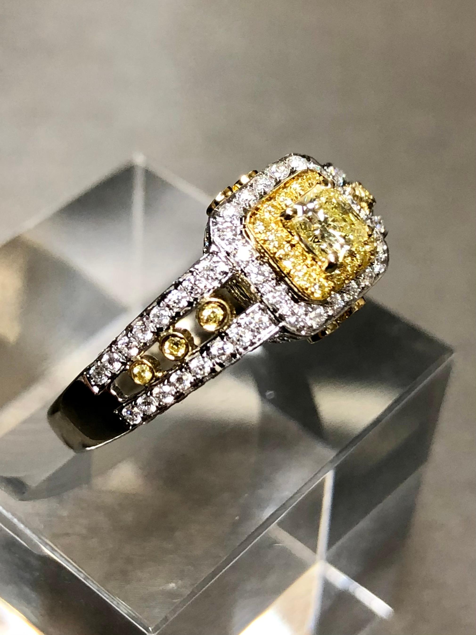An estate ring by known maker CANARY STAR done in 18K white and yellow gold centered by a stunning .42ct (known weight stamped in shank) natural fancy yellow cut-cornered radiant cut diamond being Si1 and clarity. Surrounding the center stone is