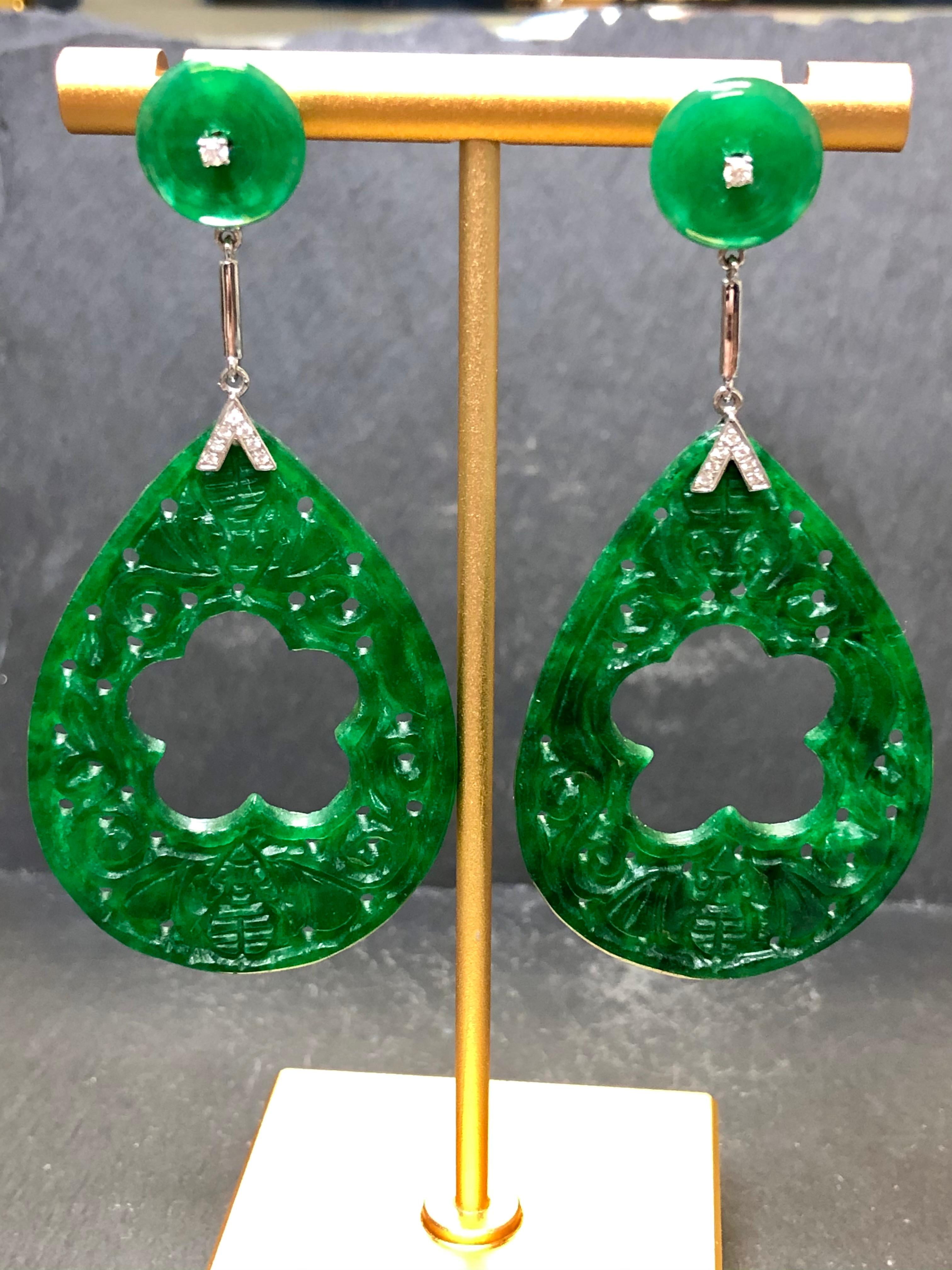 
Ein schönes und dramatisches Paar kunstvoll geschnitzter Jade-Ohrringe. Wir glauben, dass sie neueren Datums sind, aber dennoch von schöner Qualität. Sie sind mit ungefähr .12cttw in G-H Vs Klarheit runde Diamanten gesetzt... aber das sind nur